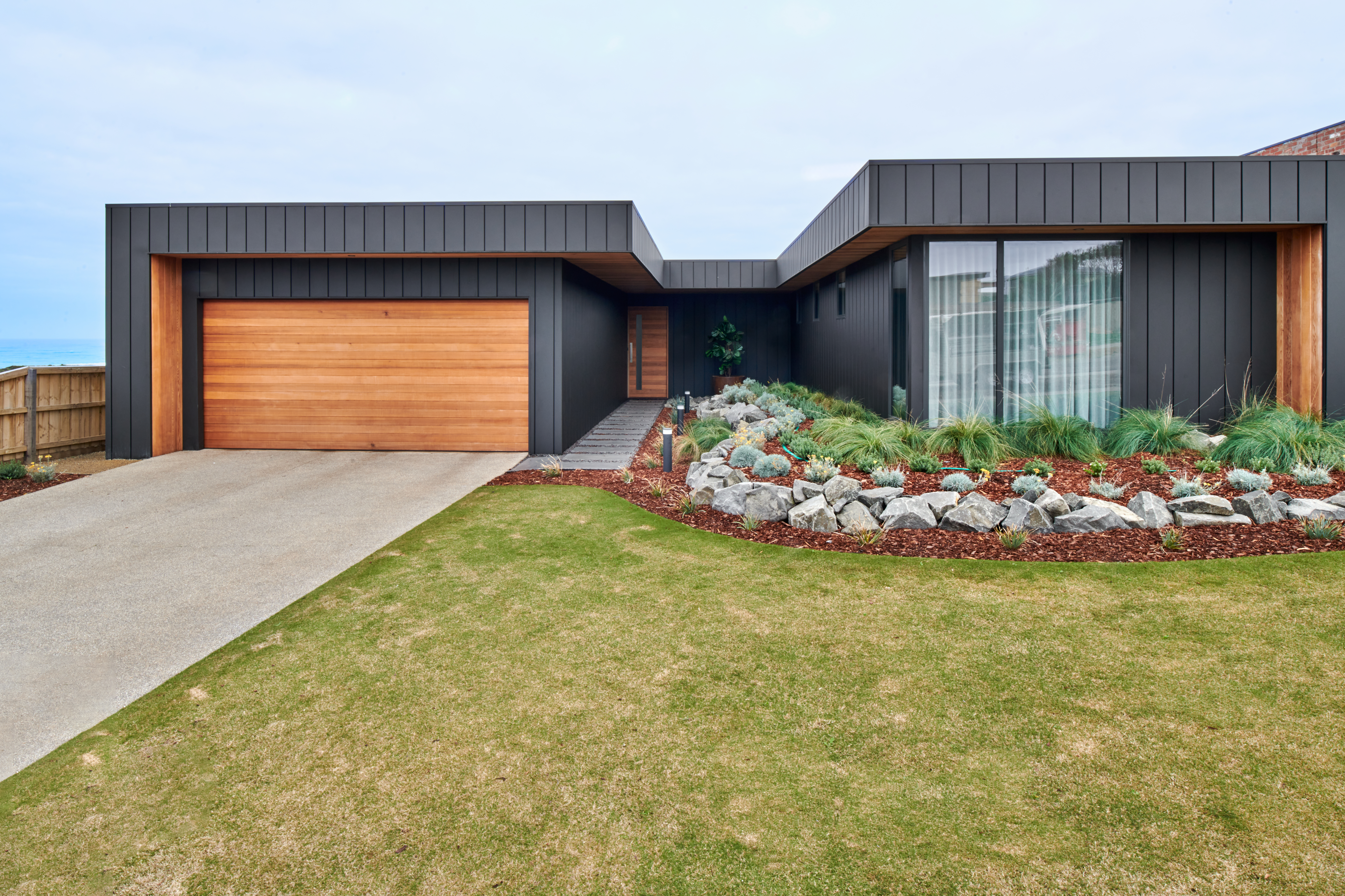 Black modern house with wood garage door