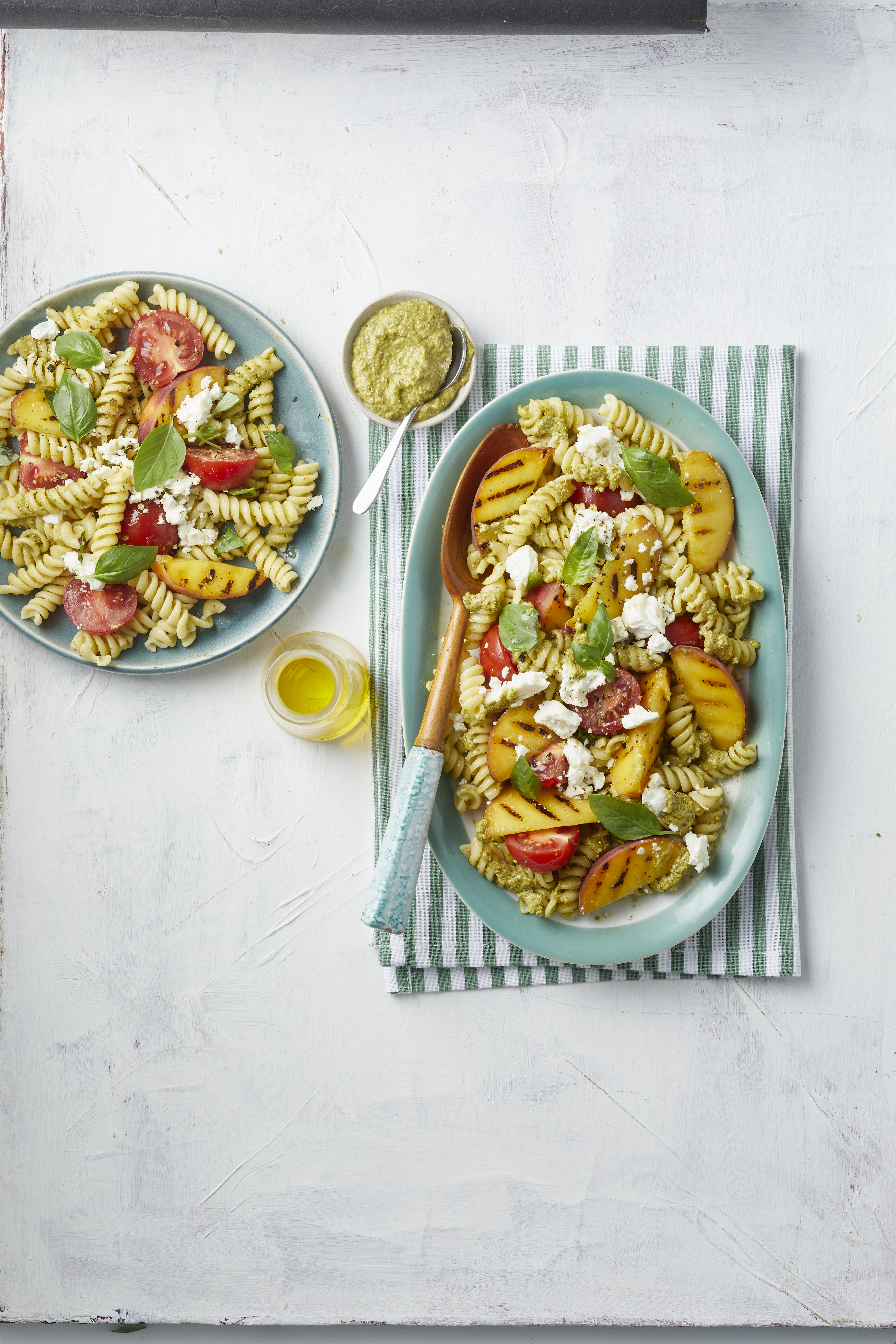 Koude pastasalade met pesto, gegrilde perzik, cocktailtomaten en feta