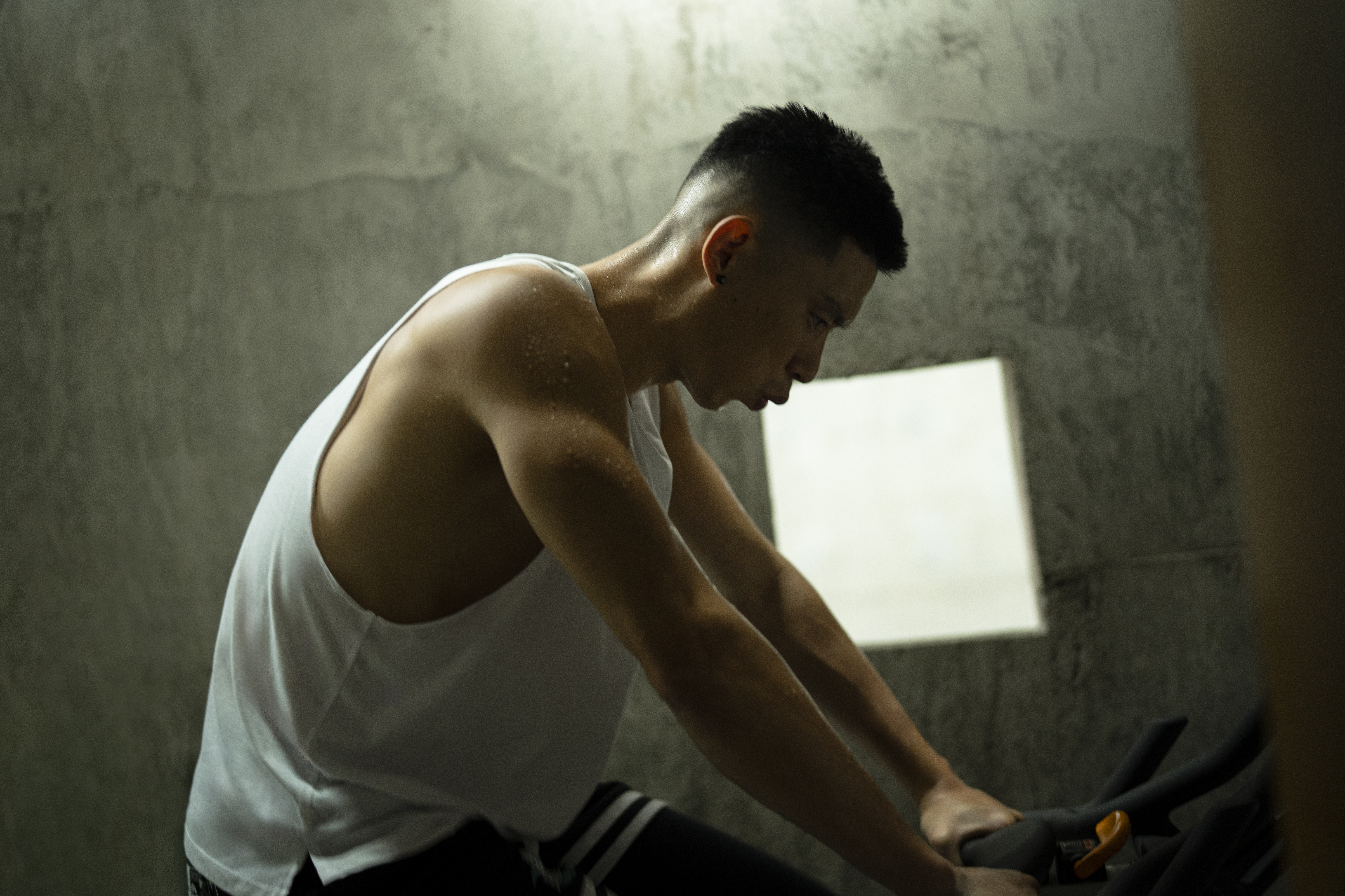 Jeremy Lin sits on exercise bike, side profile