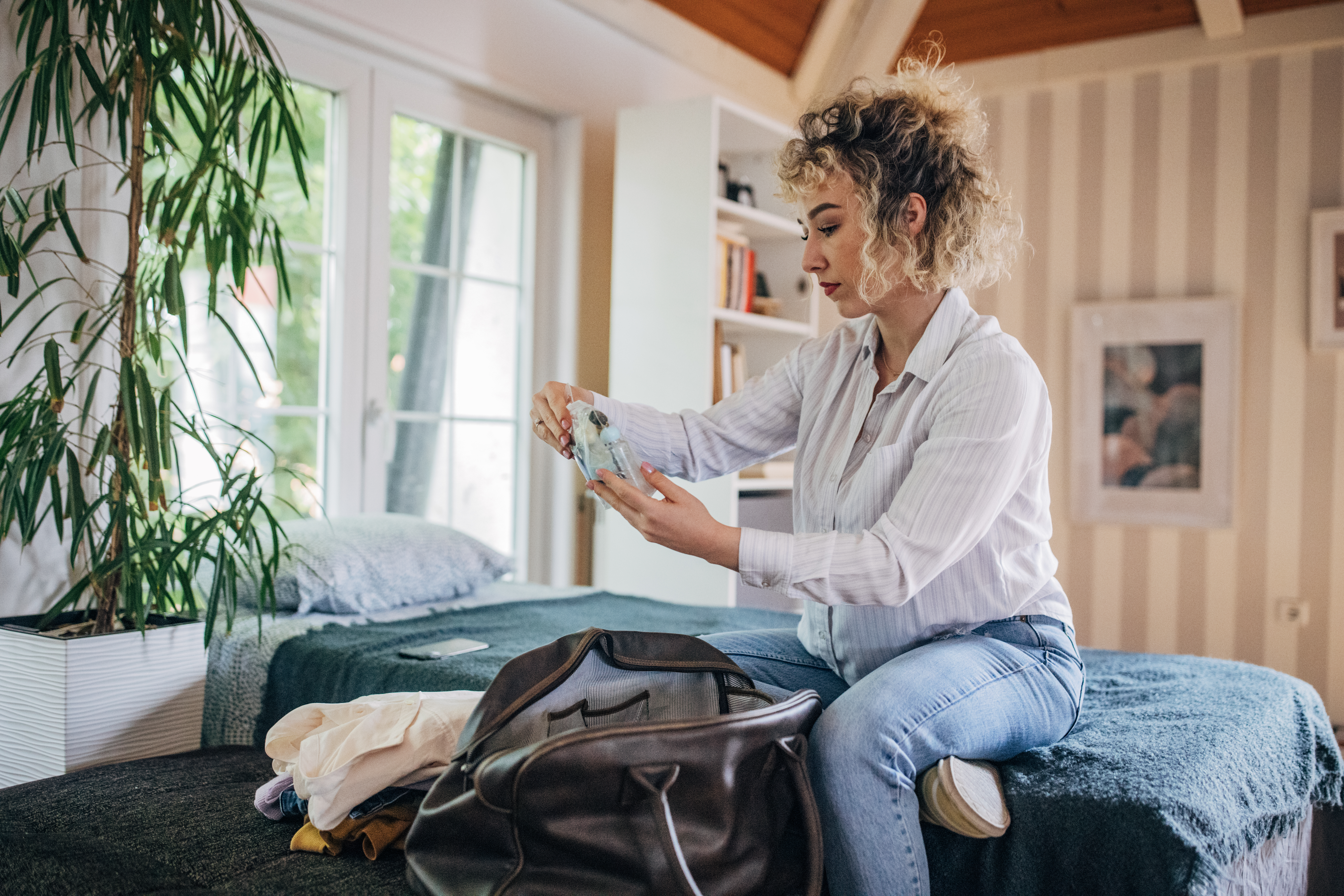 Curly haired woman packing medicine for hospital
