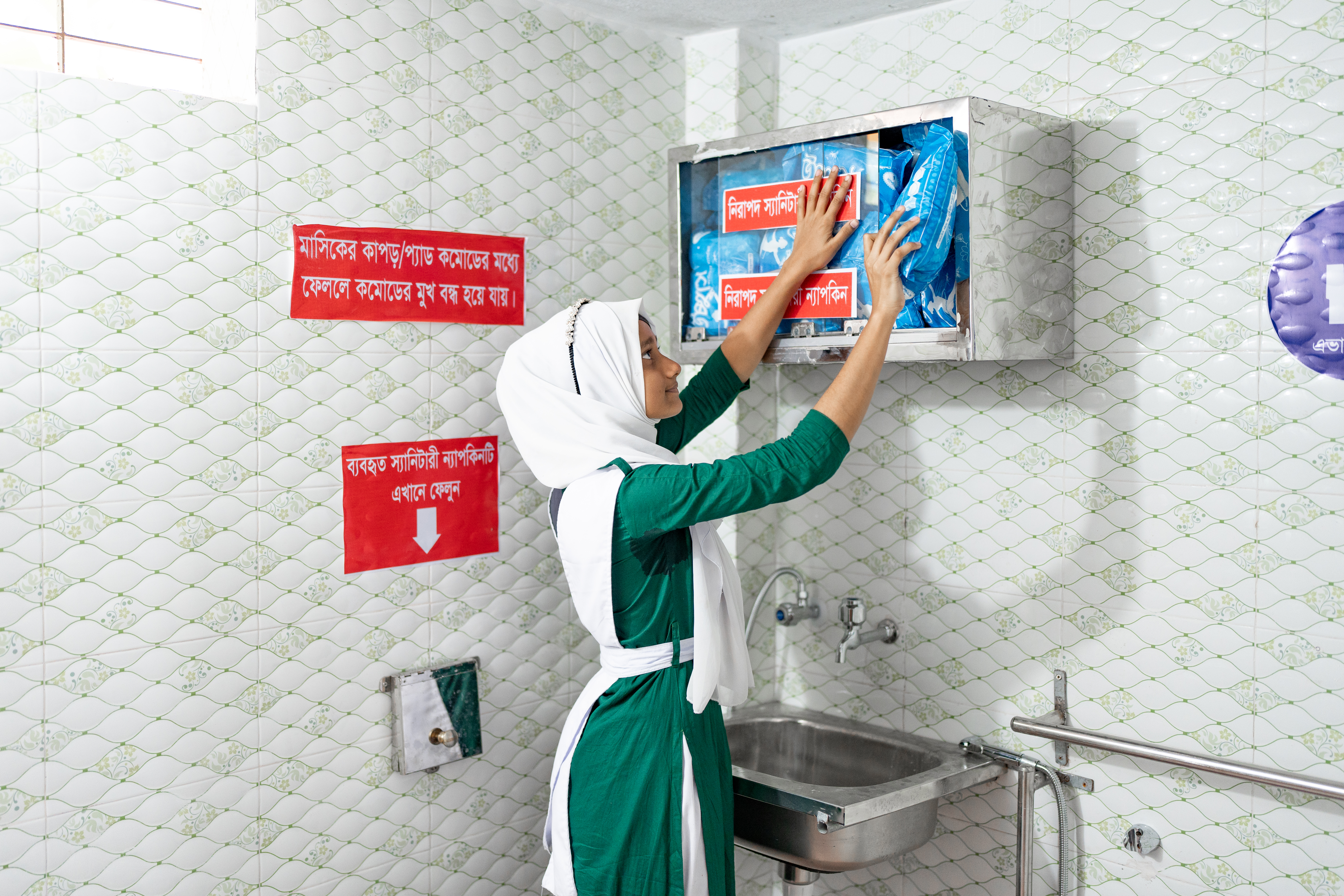 Photo of Jui restocking the women's bathroom
