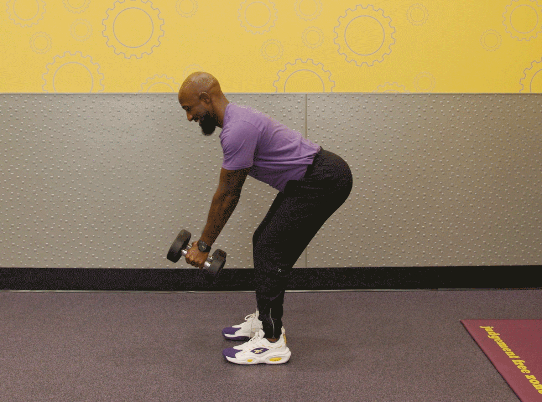 Man performing bent row exercise with dumbbells in Planet Fitness club