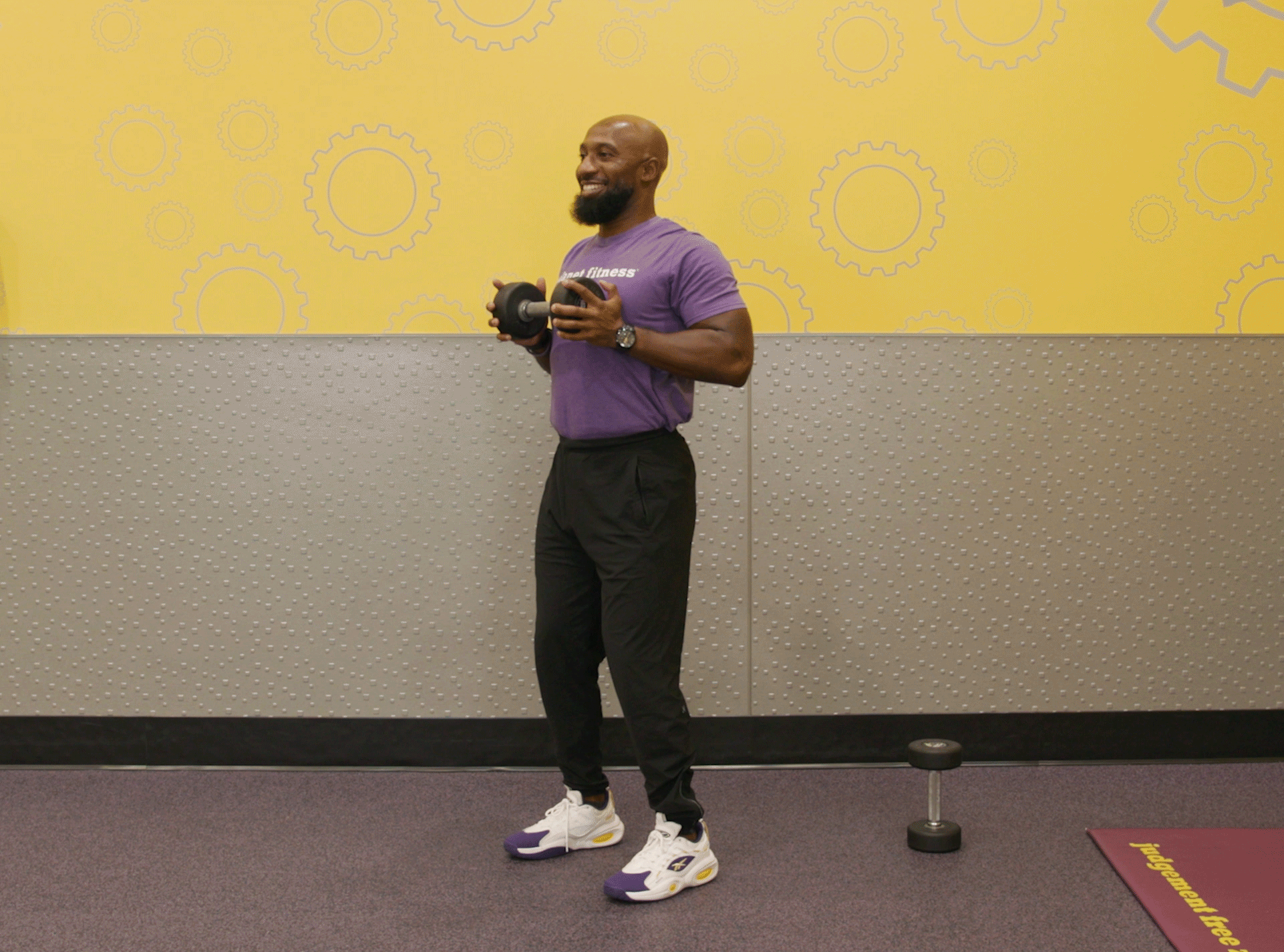 Man performing svend press exercise with dumbbells in Planet Fitness club