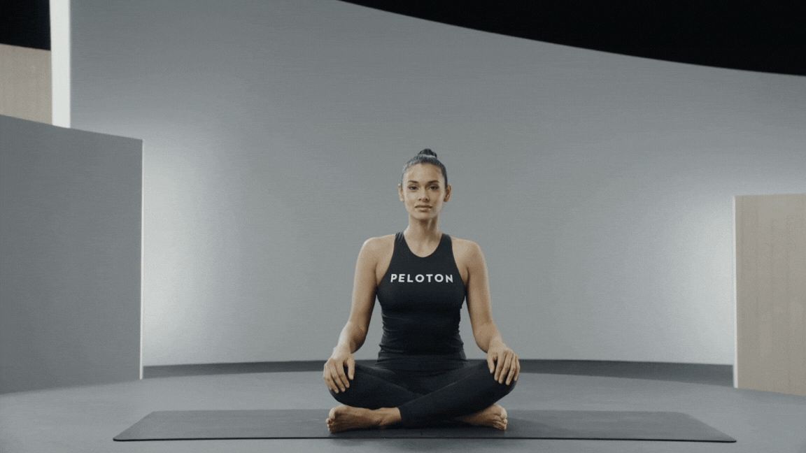 Peloton instructor Aditi Shah demonstrating the cow face pose seated yoga posture