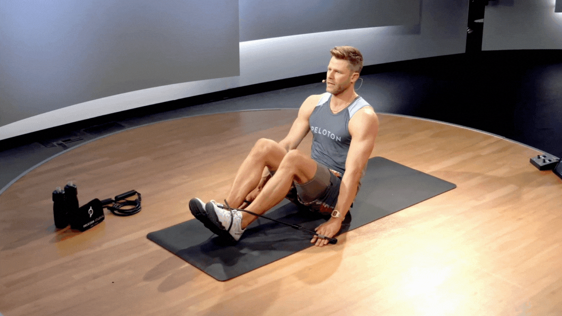 Peloton instructor Andy Speer demonstrates a resistance band tuck up.