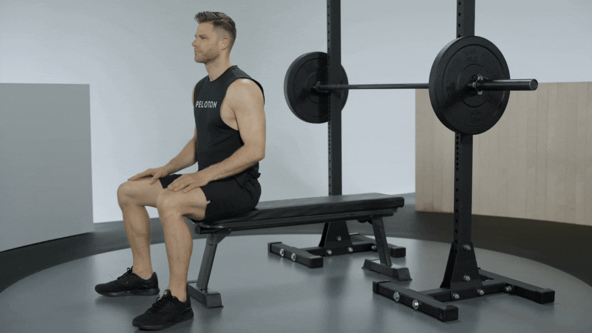 Andy Speer demonstrates a barbell bench press exercise on workout bench