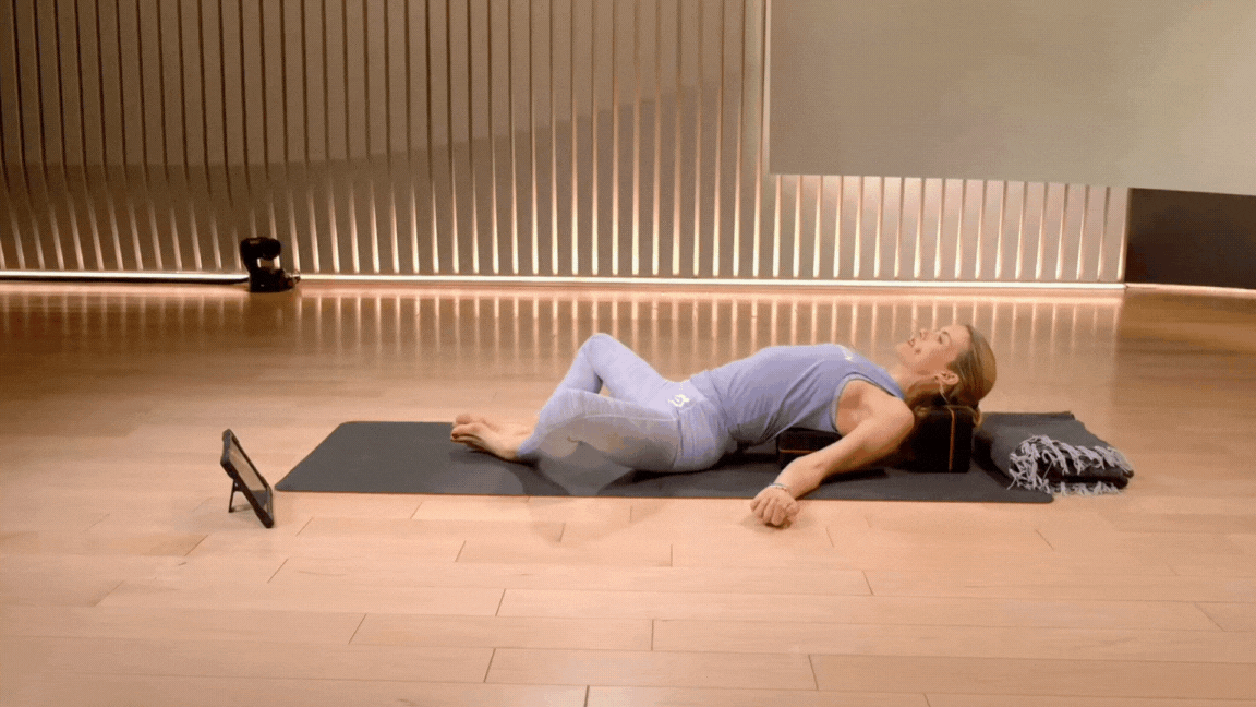 Kristin McGee demonstrates Reclined Butterfly Pose with blocks during a Peloton yoga class. 