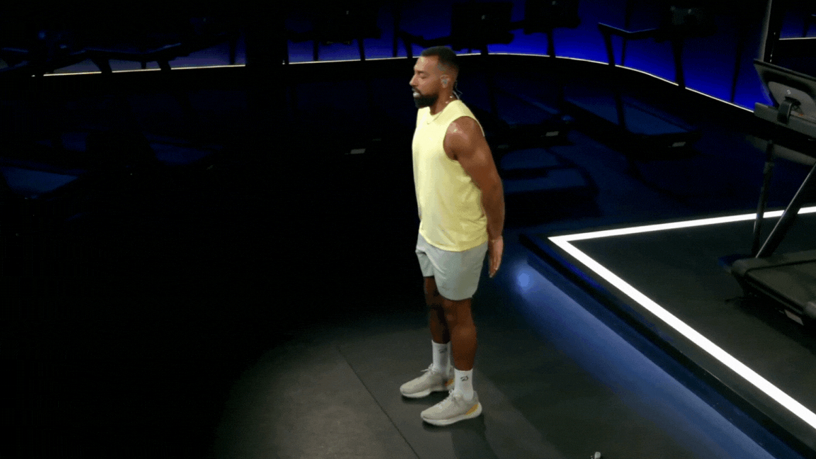 Peloton instructor Jermaine Johnson does butt kicks as a warm-up exercise in a pre-run stretch class.