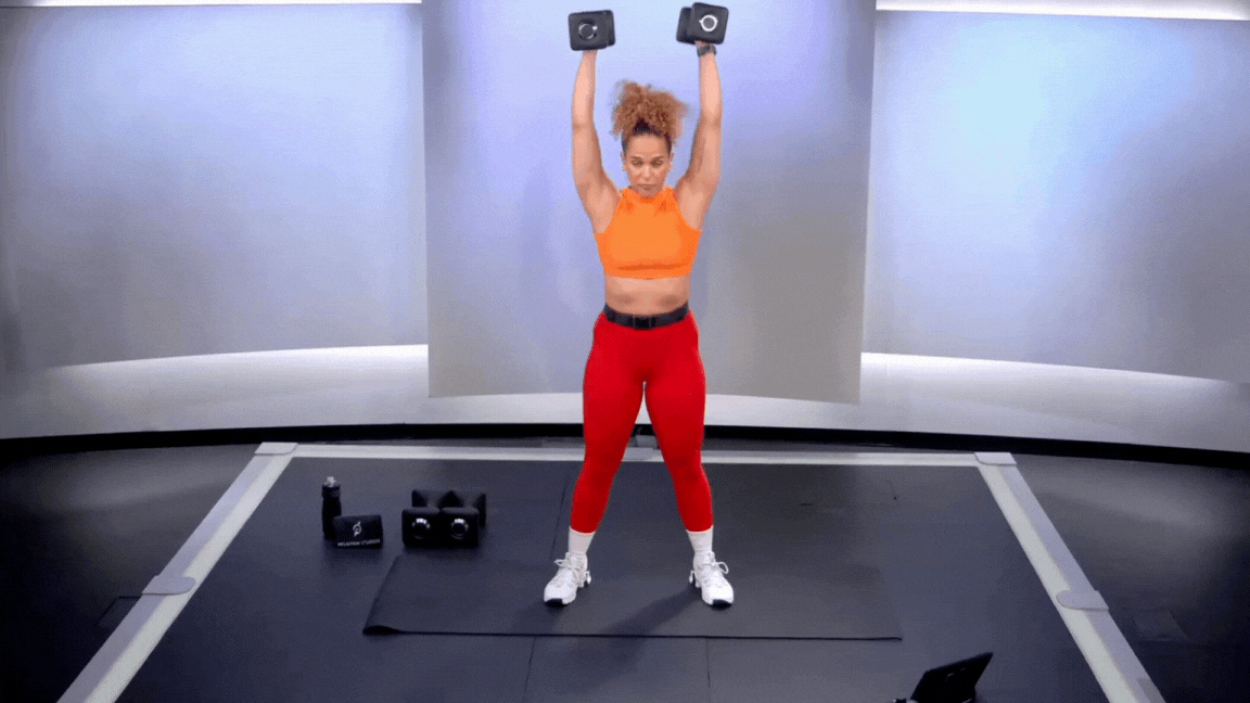 Peloton instructor Jess Sims demonstrates a dumbbell push press as part of strength training for basketball