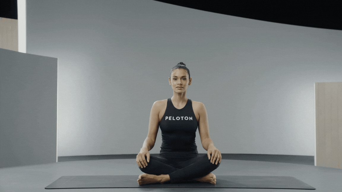 Peloton instructor Aditi Shah demonstrating Cow Face Pose.