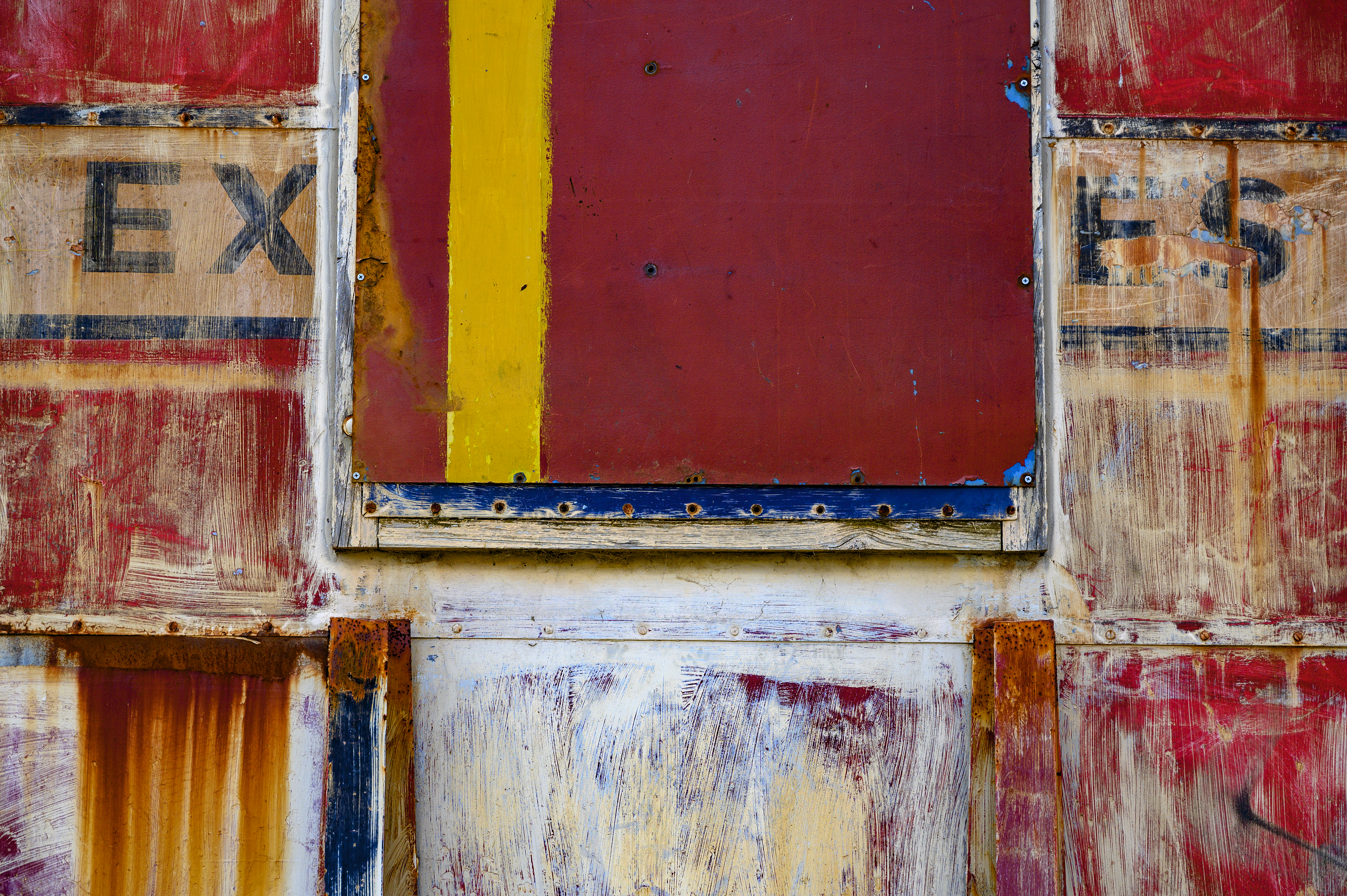 Photograph of old weathered panels that form a section of a vintage freight train carriage.