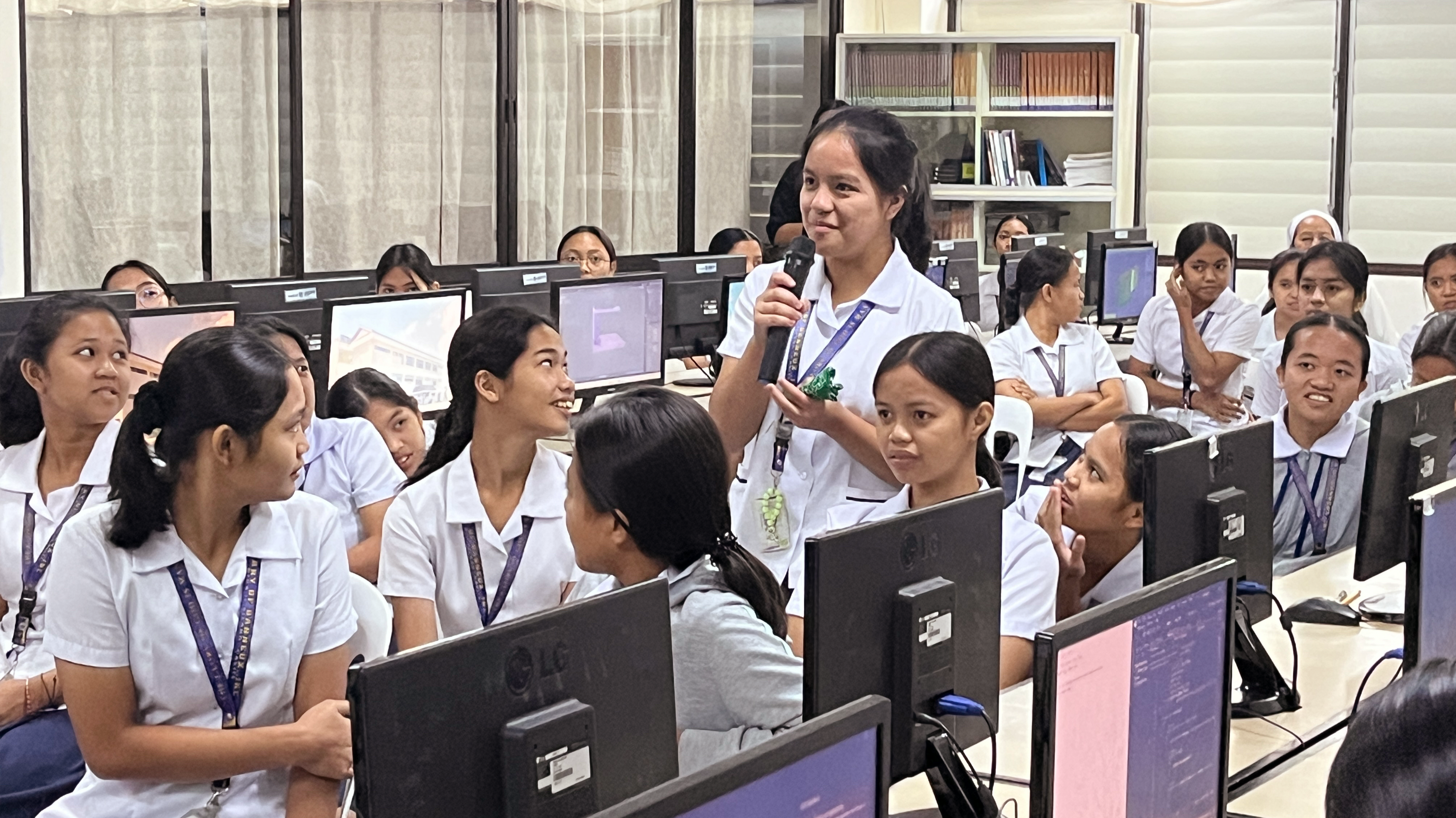 school girl standing with a microphone in the middle of the class