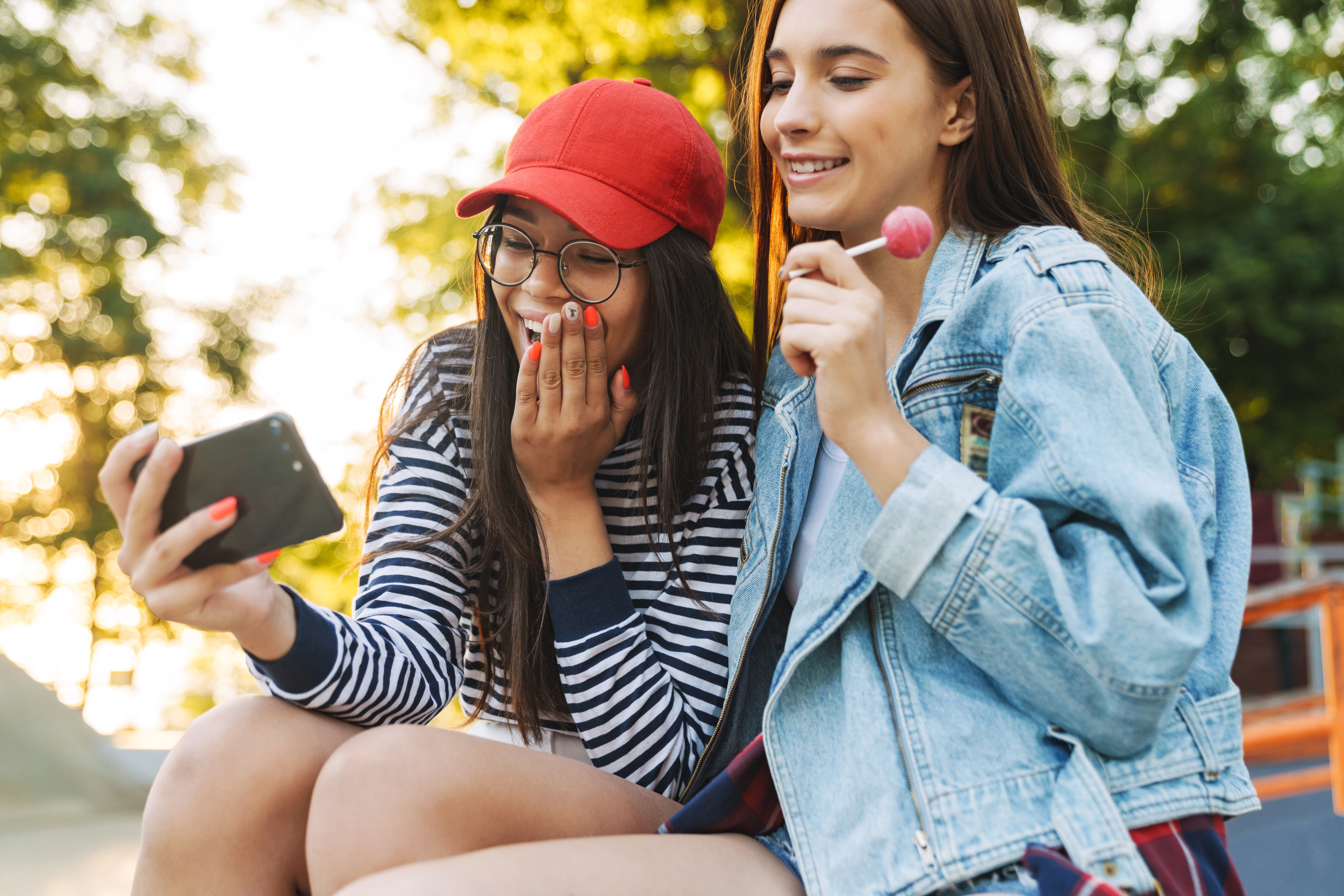 Two girls smiling while looking at a phone