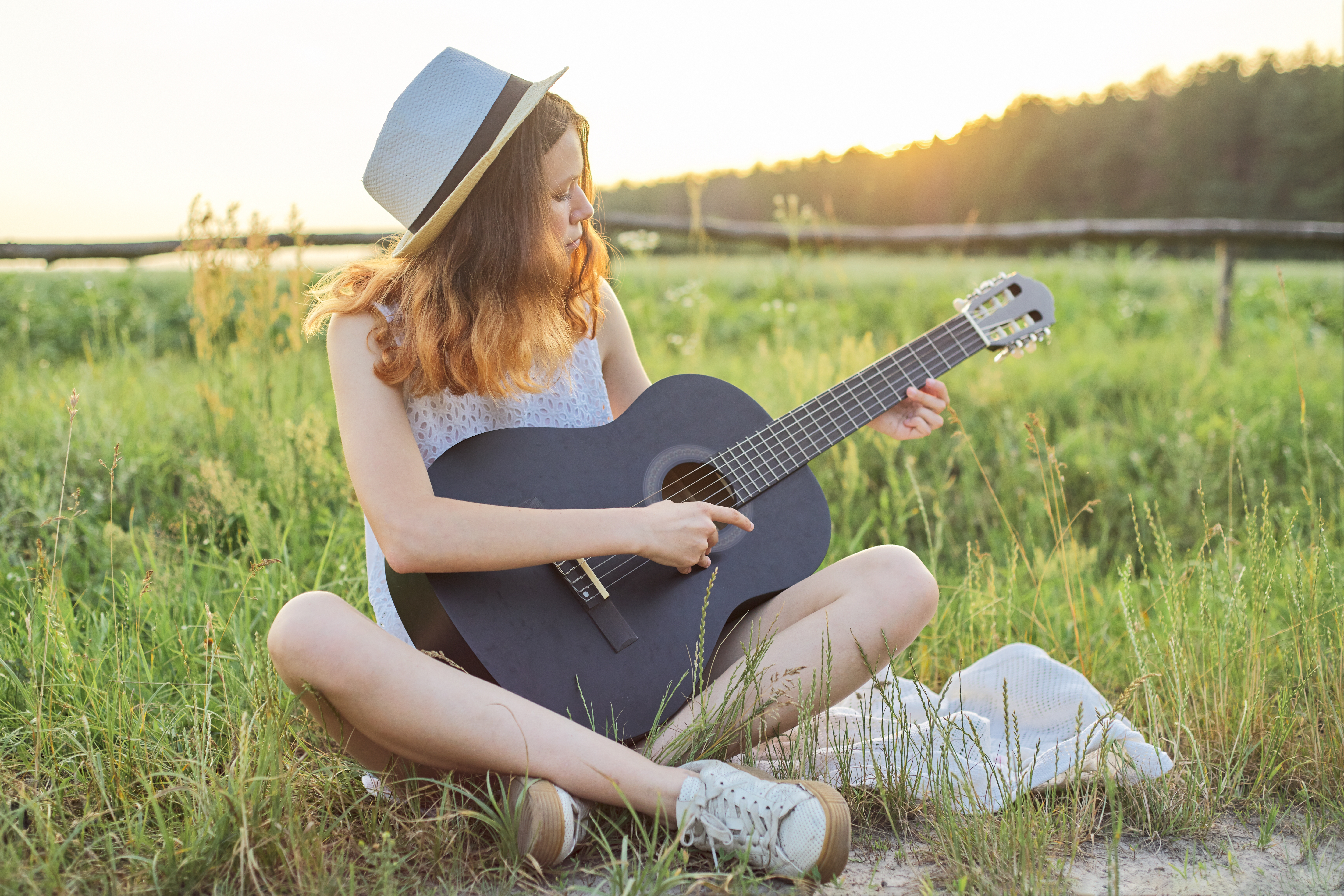 Girl playing a guitar in a field