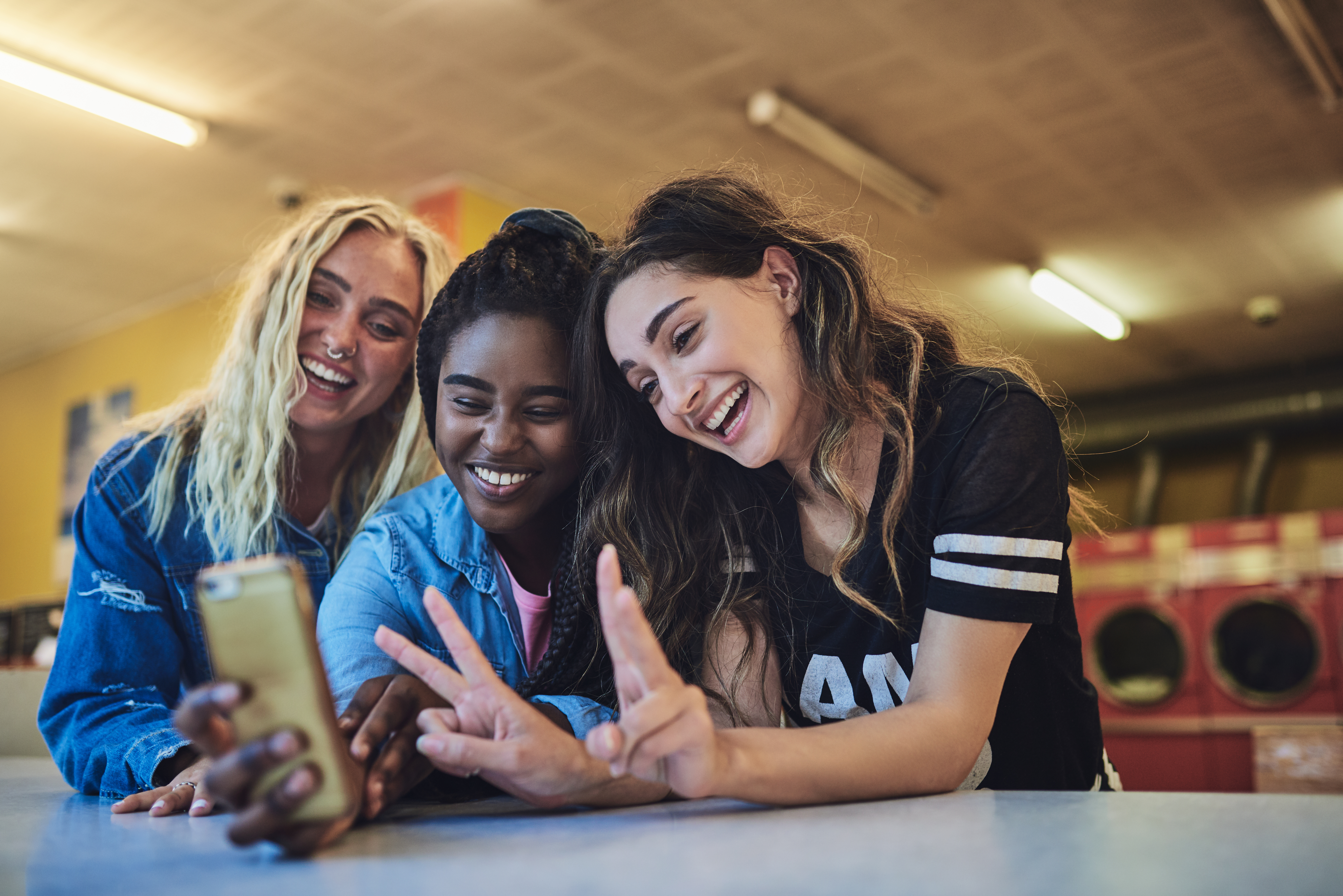 Three girls laughing while taking a selfie