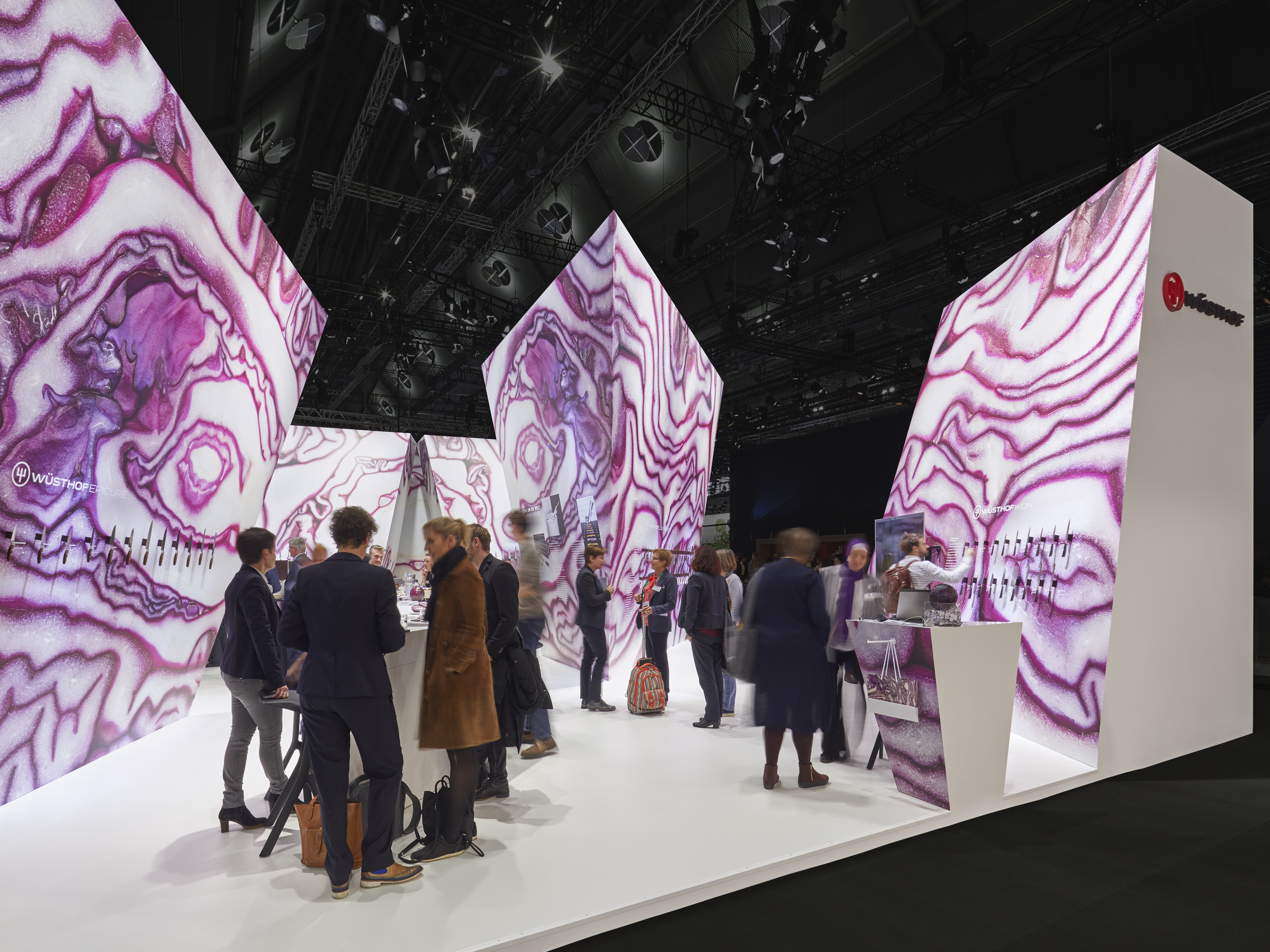  A diverse group of people gathered around a marble display, admiring the various colors and patterns of the stones