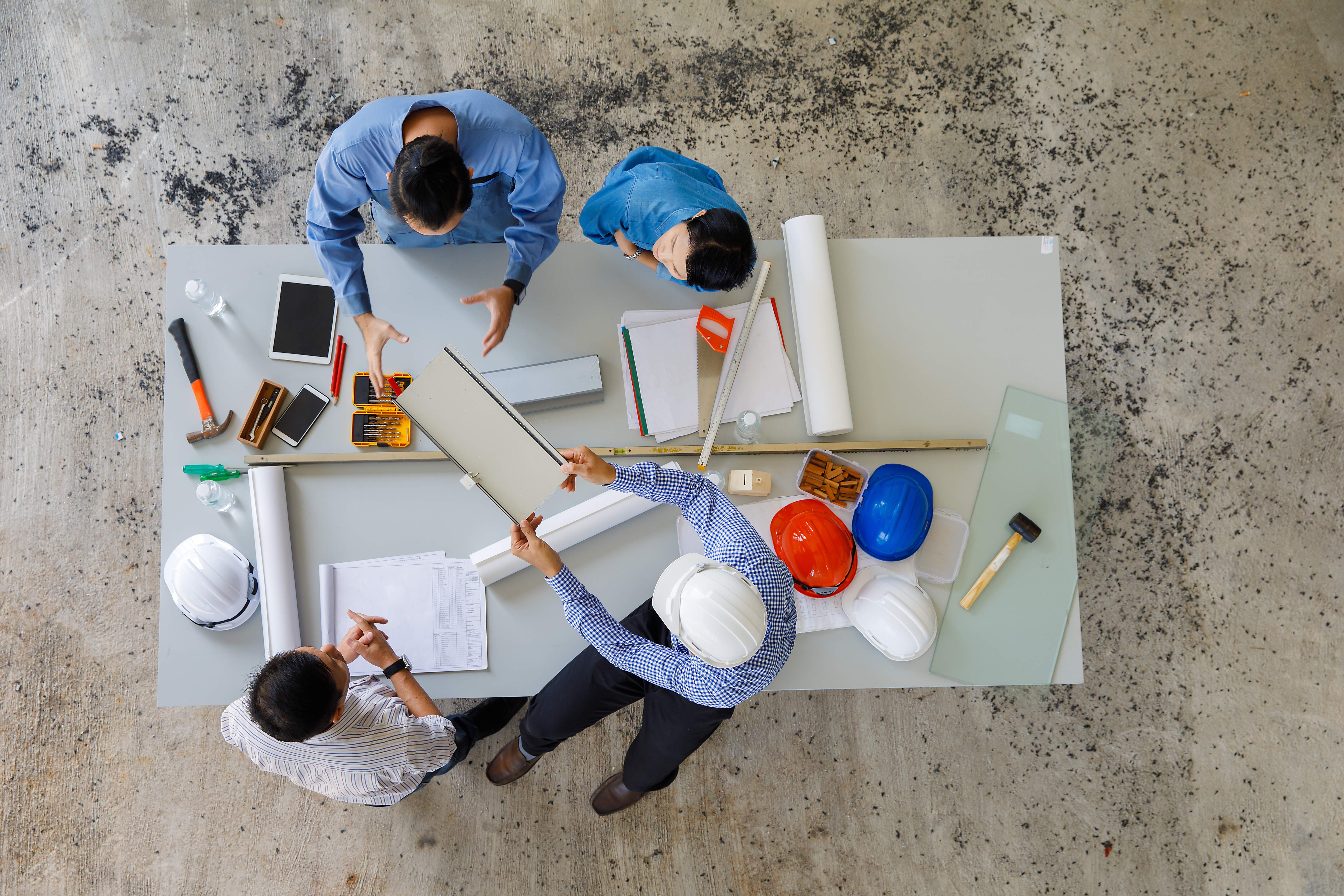 Four construction workers looking at an drawings at a table