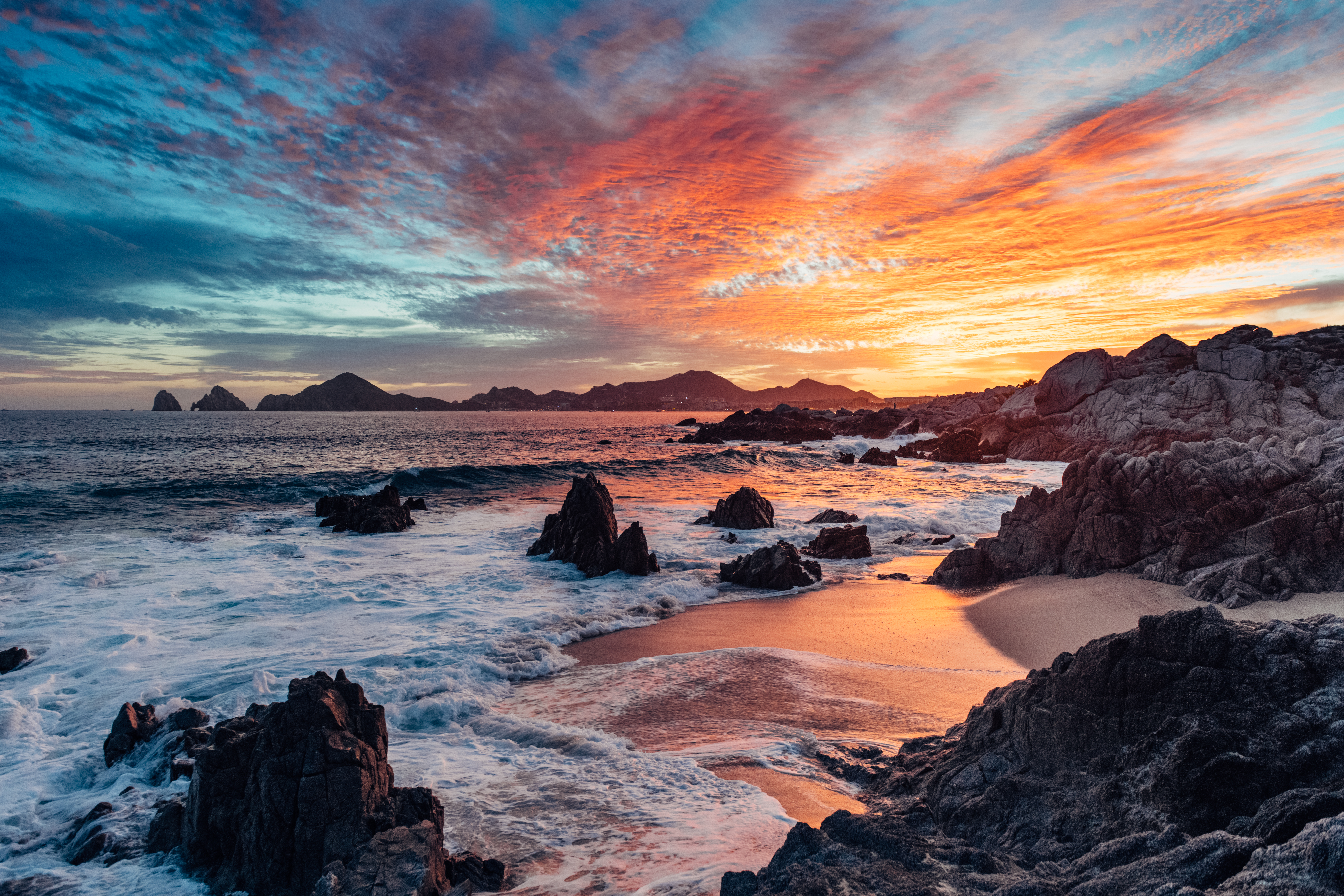 Swoop | a picture of a beach in Los Cabos, Mexico during sunset