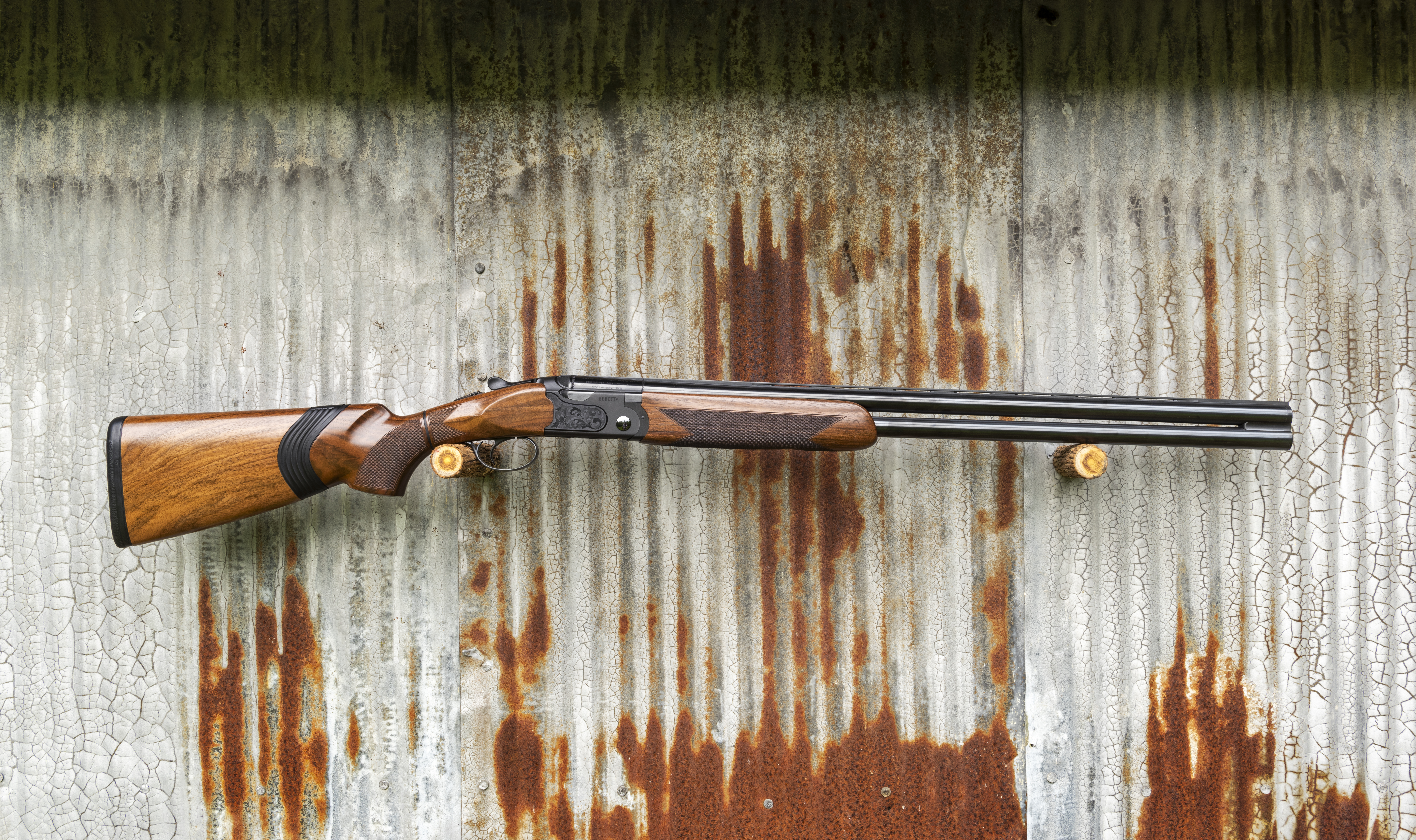 The new Beretta Ultraleggero Kick-Off over/under shotgun of a wall of corrugated tin.