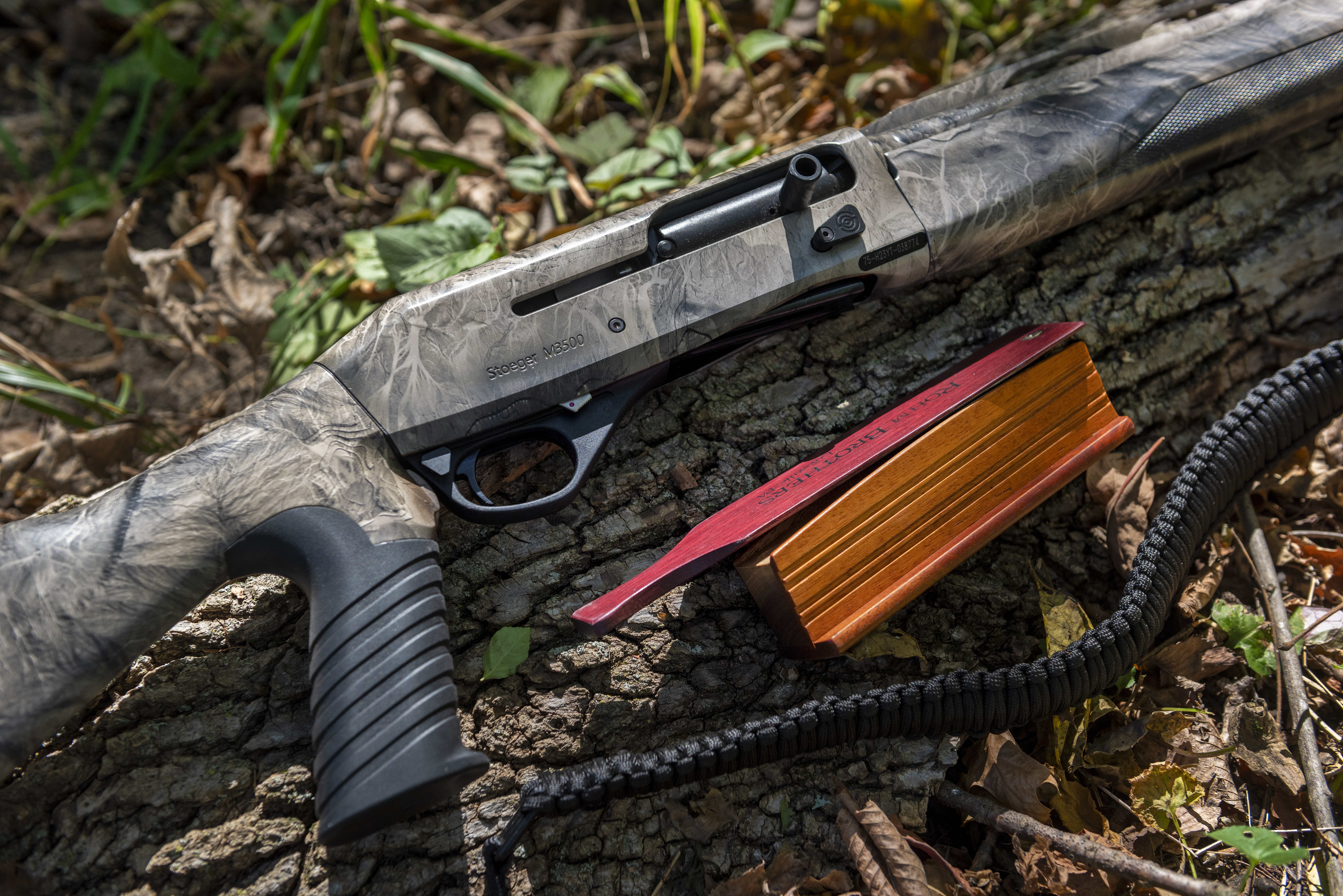 The new Stoeger 3500 Predator/Turkey shotgun on a log with turkey call.