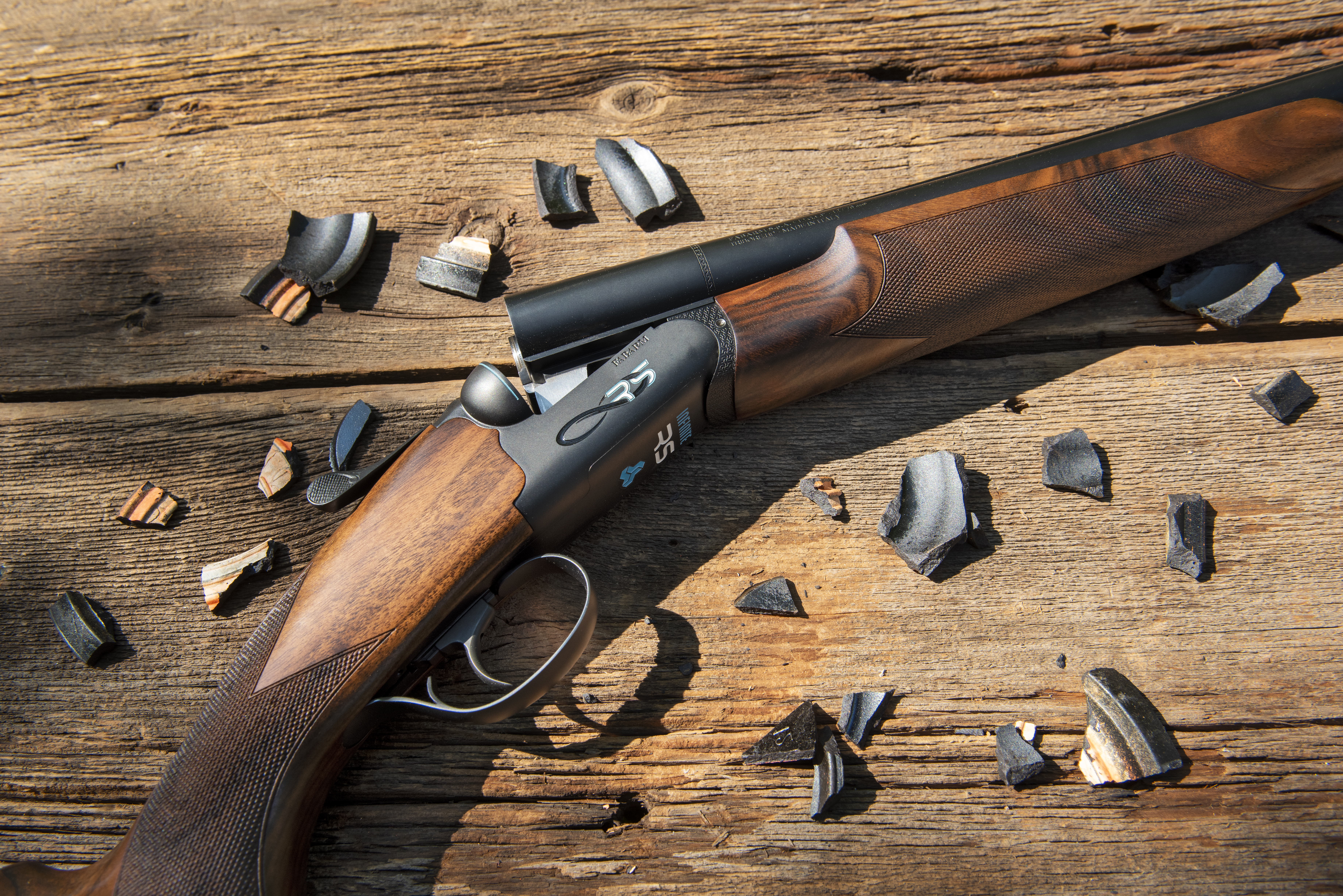 The new Fabarm Infinite RS shotgun one wood background with bits of a broken clay target. 