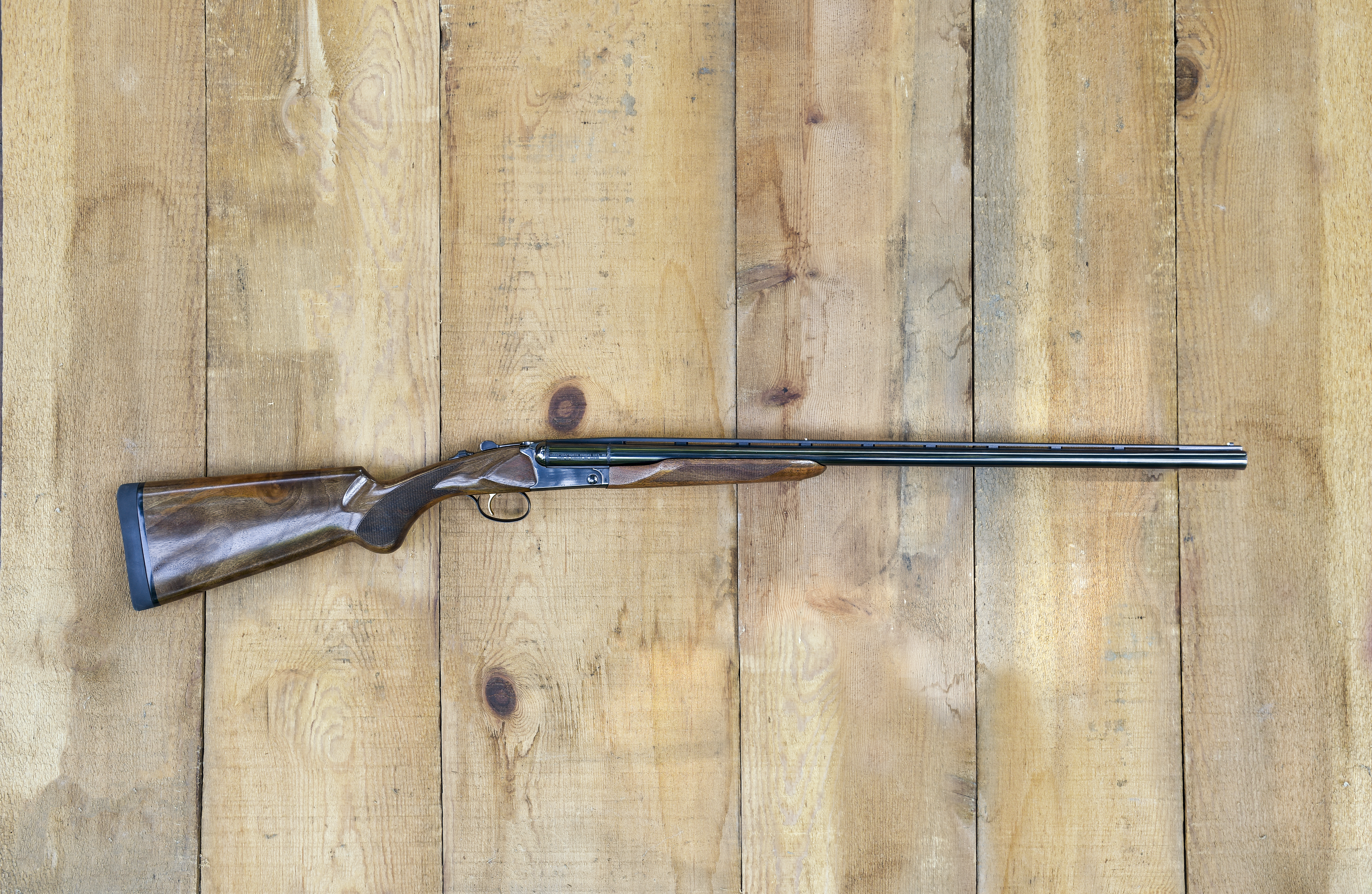 The new Akkar High Noon side-by-side shotgun on barn boards.