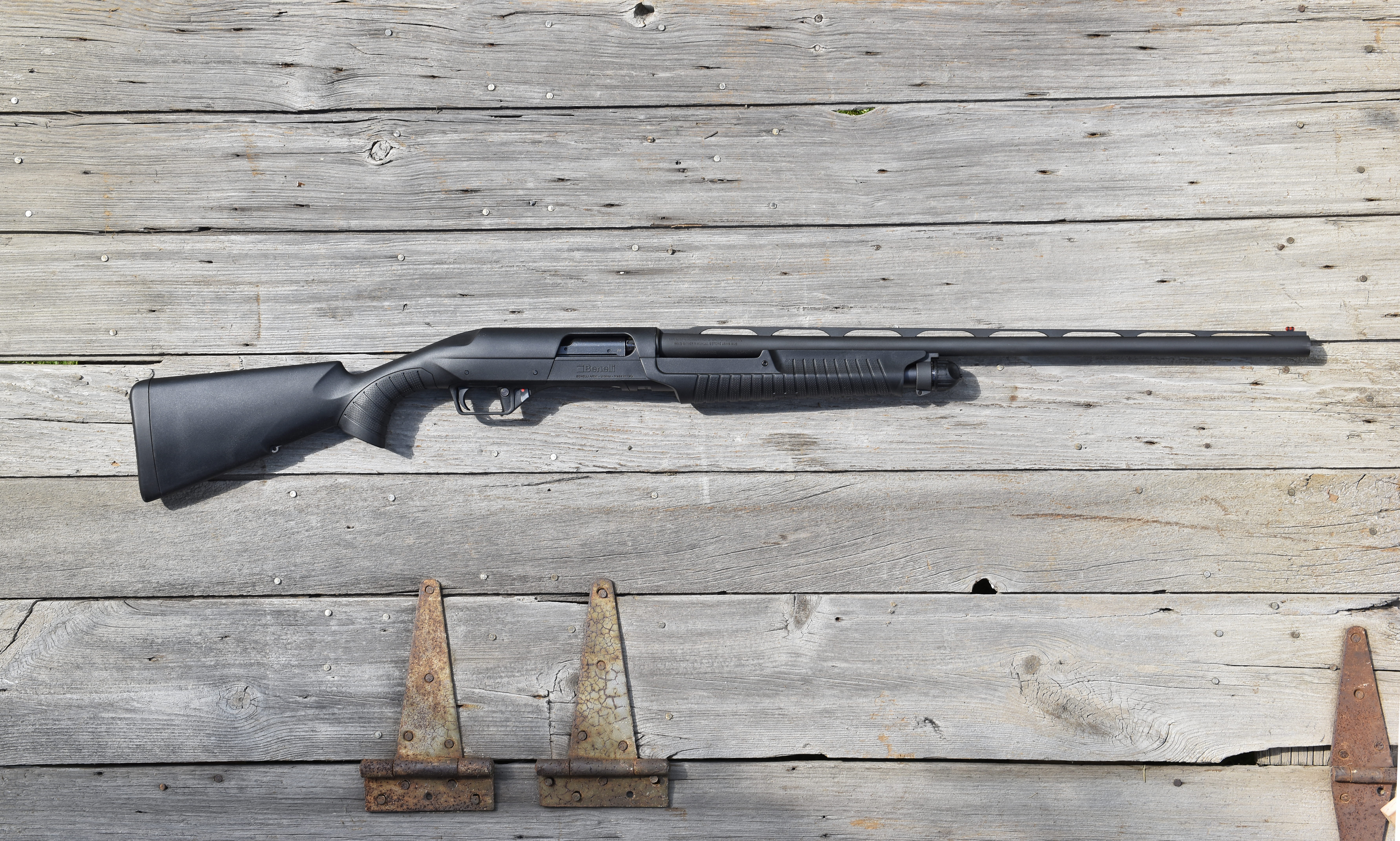 The new Benelli Nova 3 shotgun lying on barn boards.