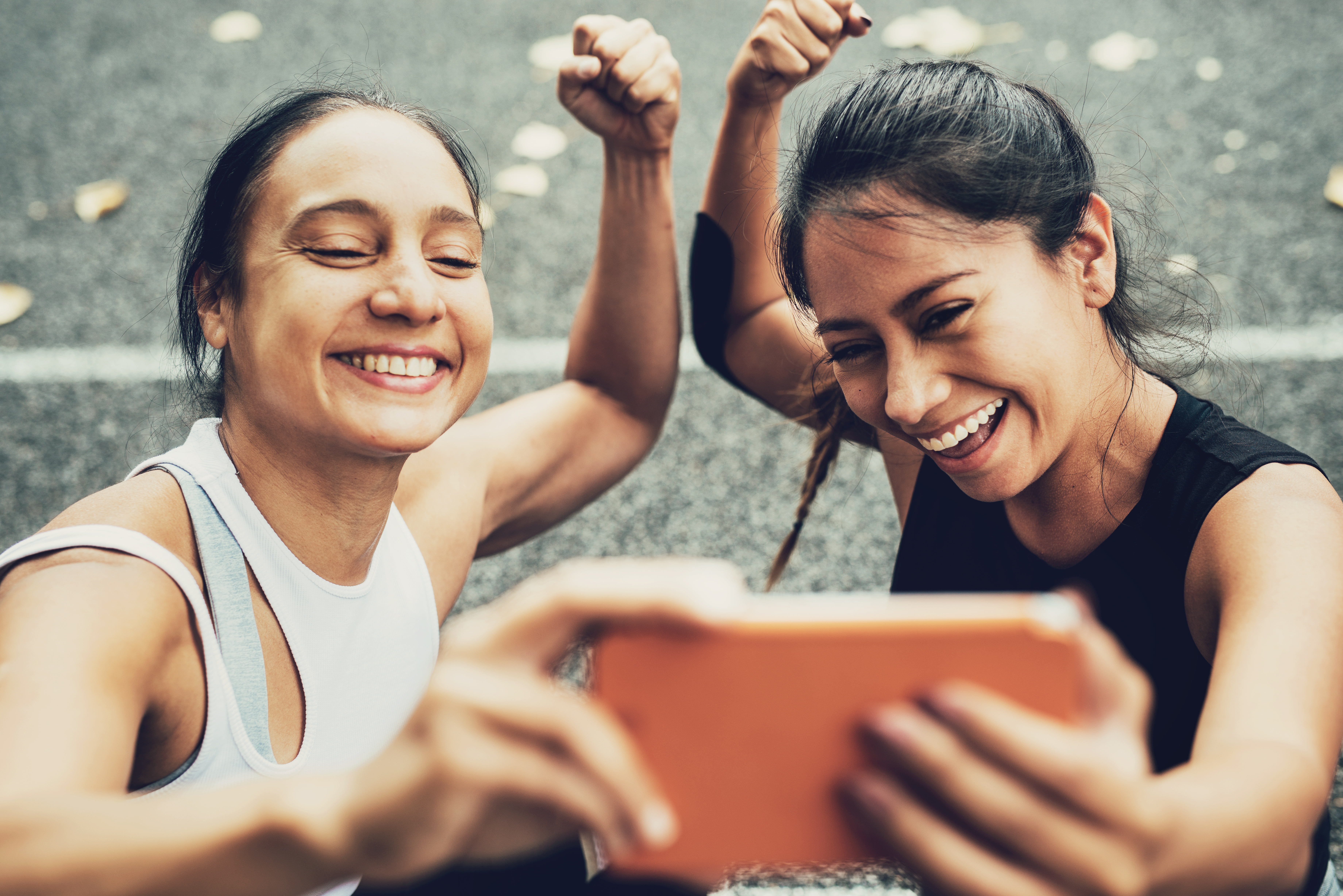 Two girls take a selfie while flexing their arms