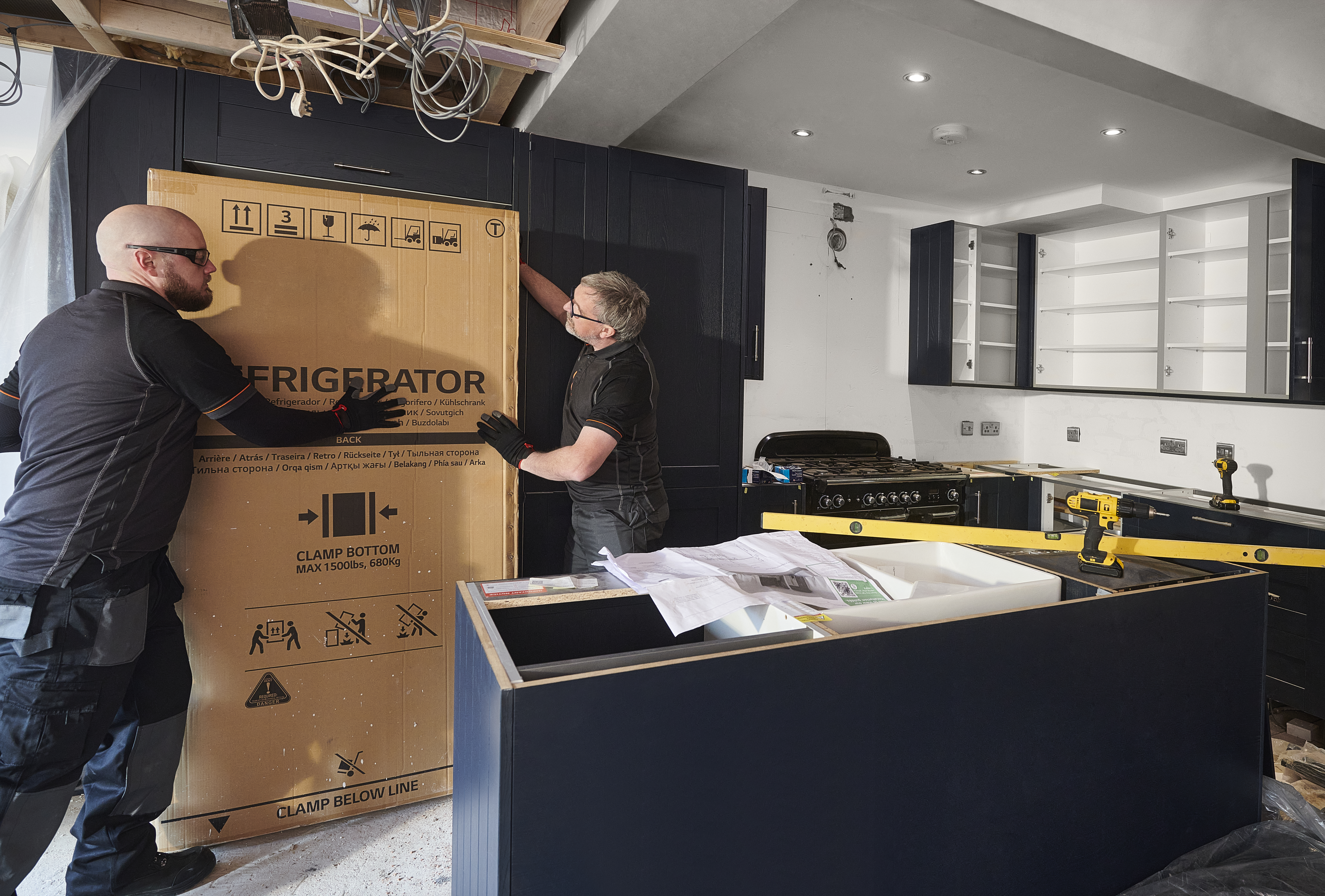 Two construction workers completing a kitchen remodel