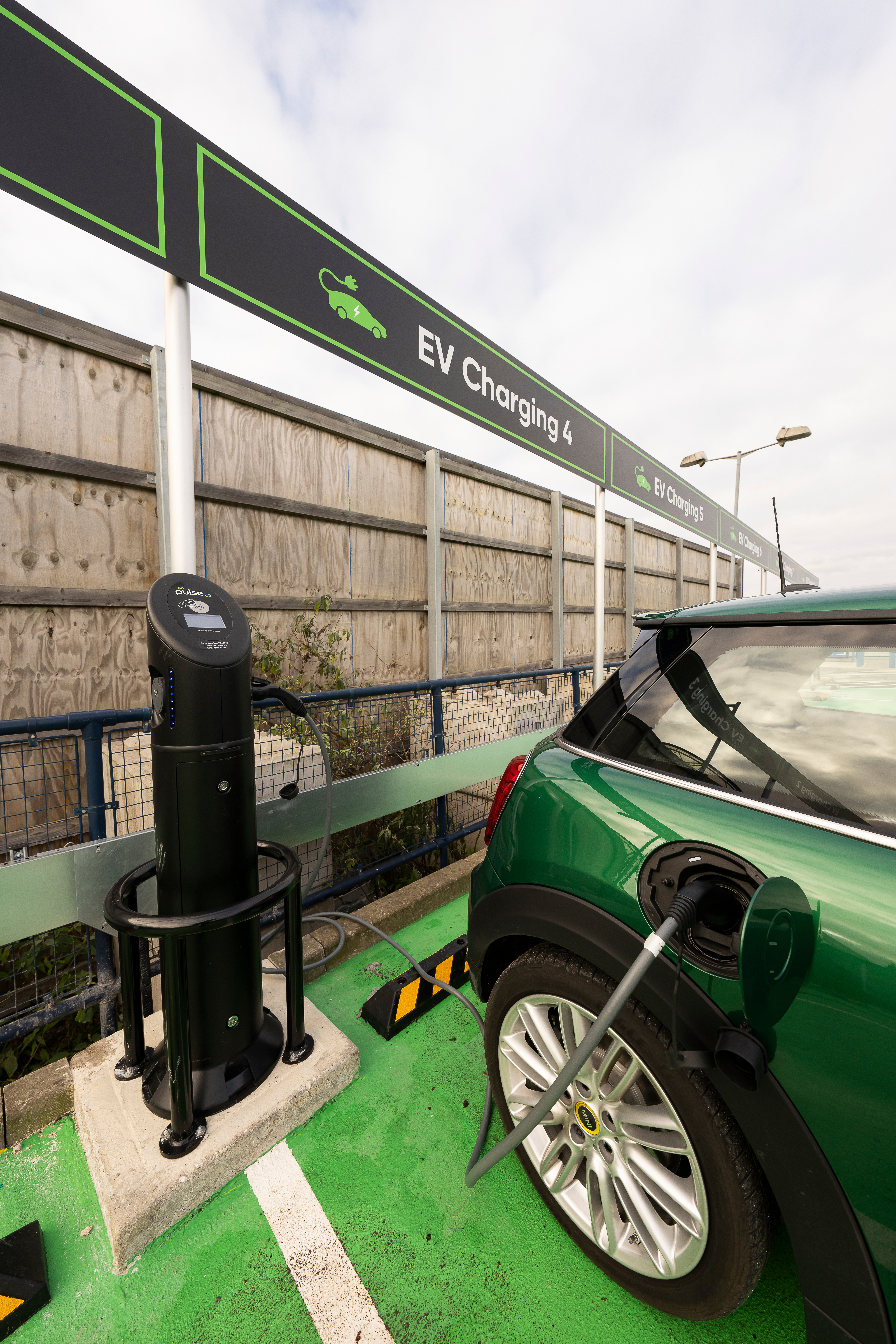 Green car charging at electric charging station