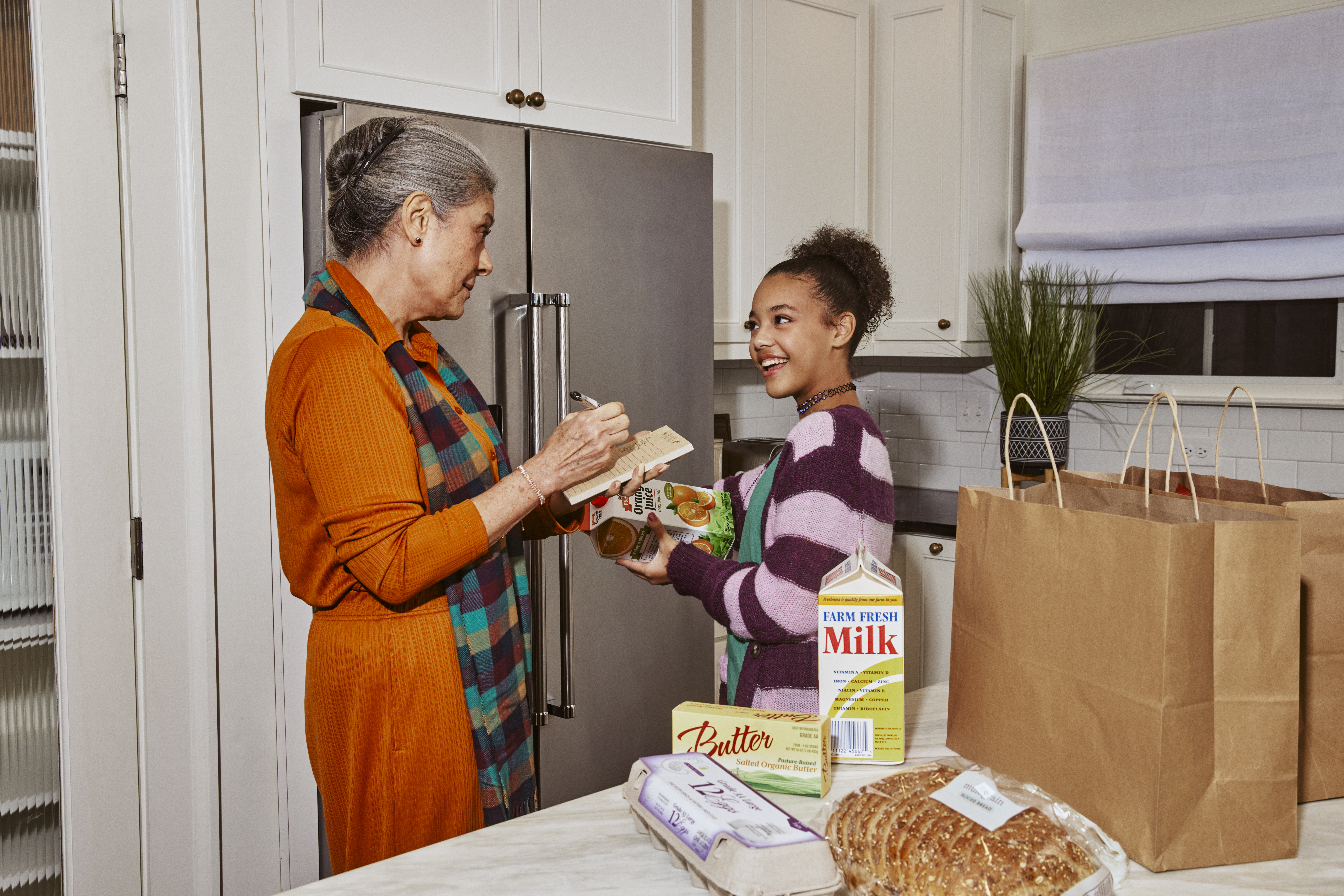 Family putting groceries away in the kitchen.