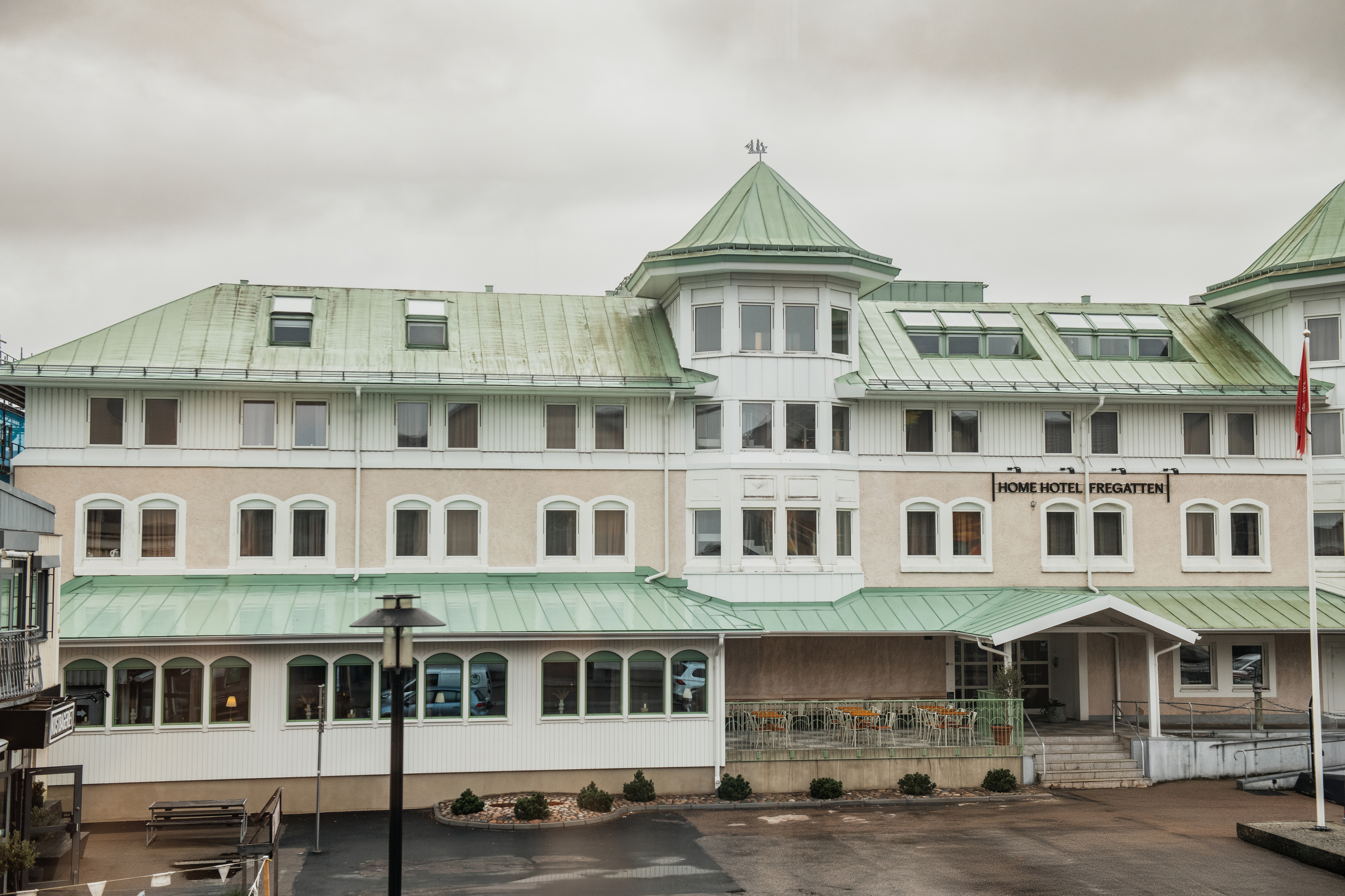 Udvendig udsigt over en hotelbygning med grønt tag og flere vinduer. Hotelnavnet FREGATTEN er synligt over indgangen.