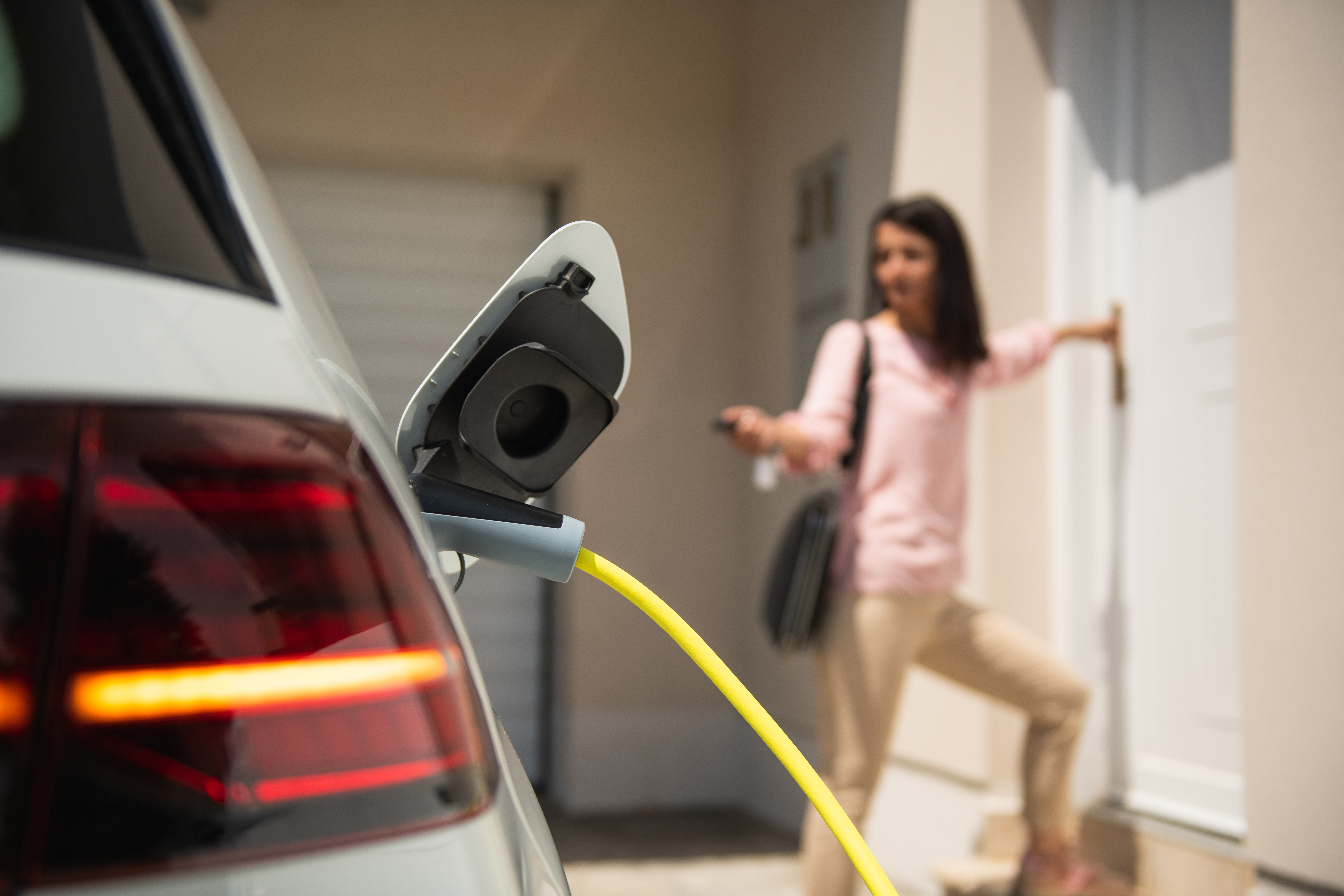 Woman Charging EV Car at Home