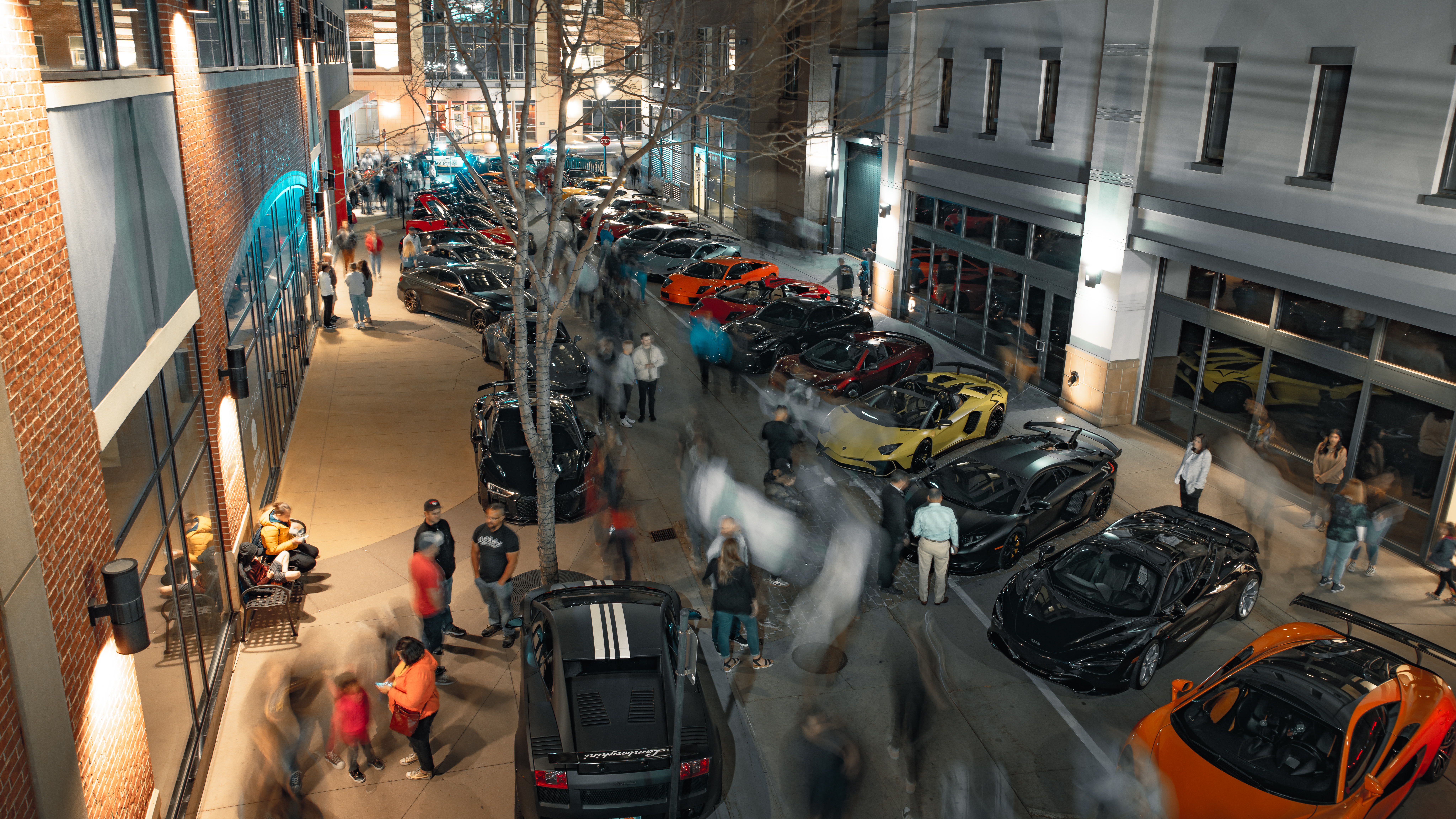 Attendees gather round supercars lined on both sides of the street in Salt Lake City