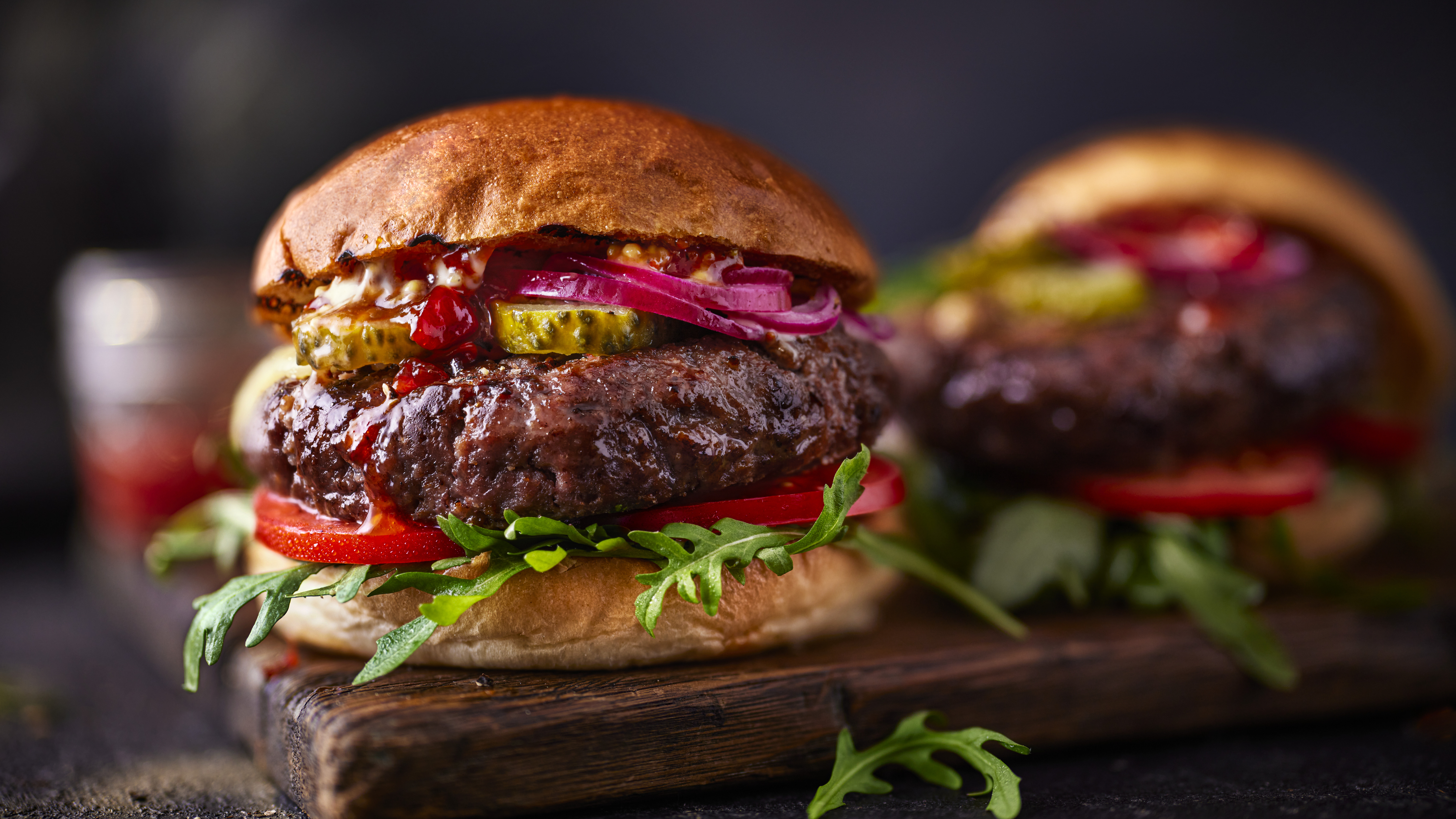 Two beef burgers on black background