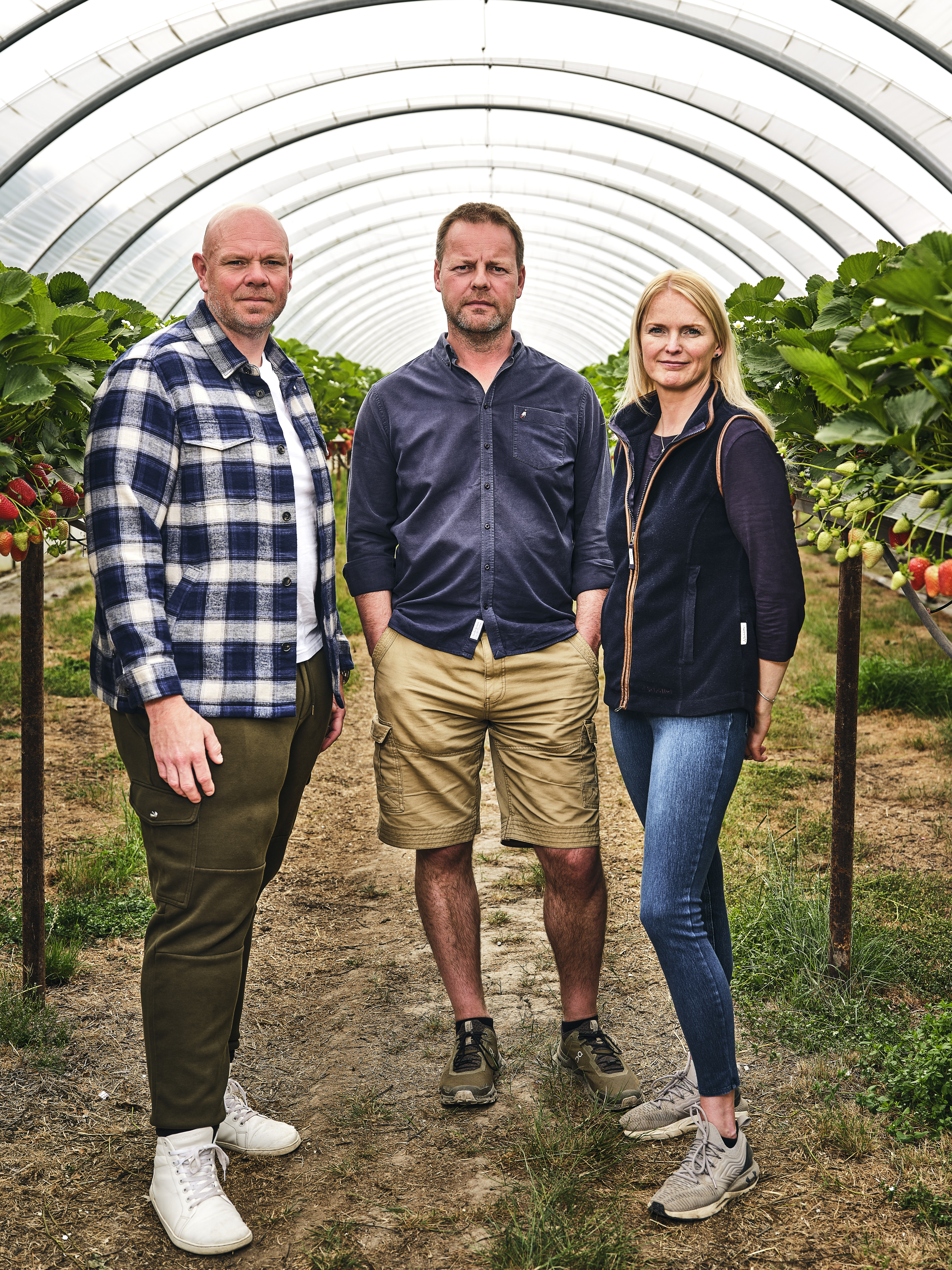 Three people in strawberry field