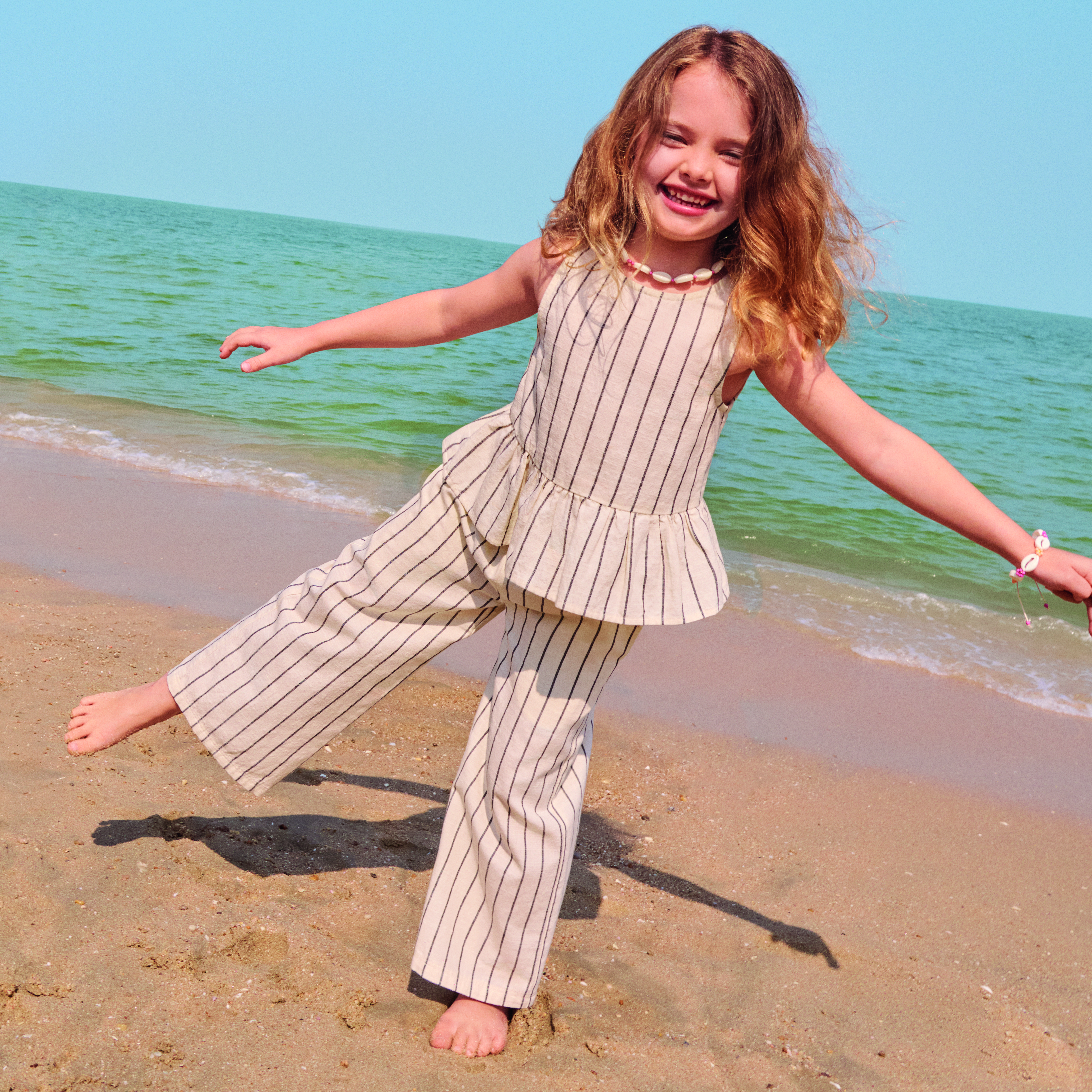 A girl wearing a striped peplum co-ord at the beach