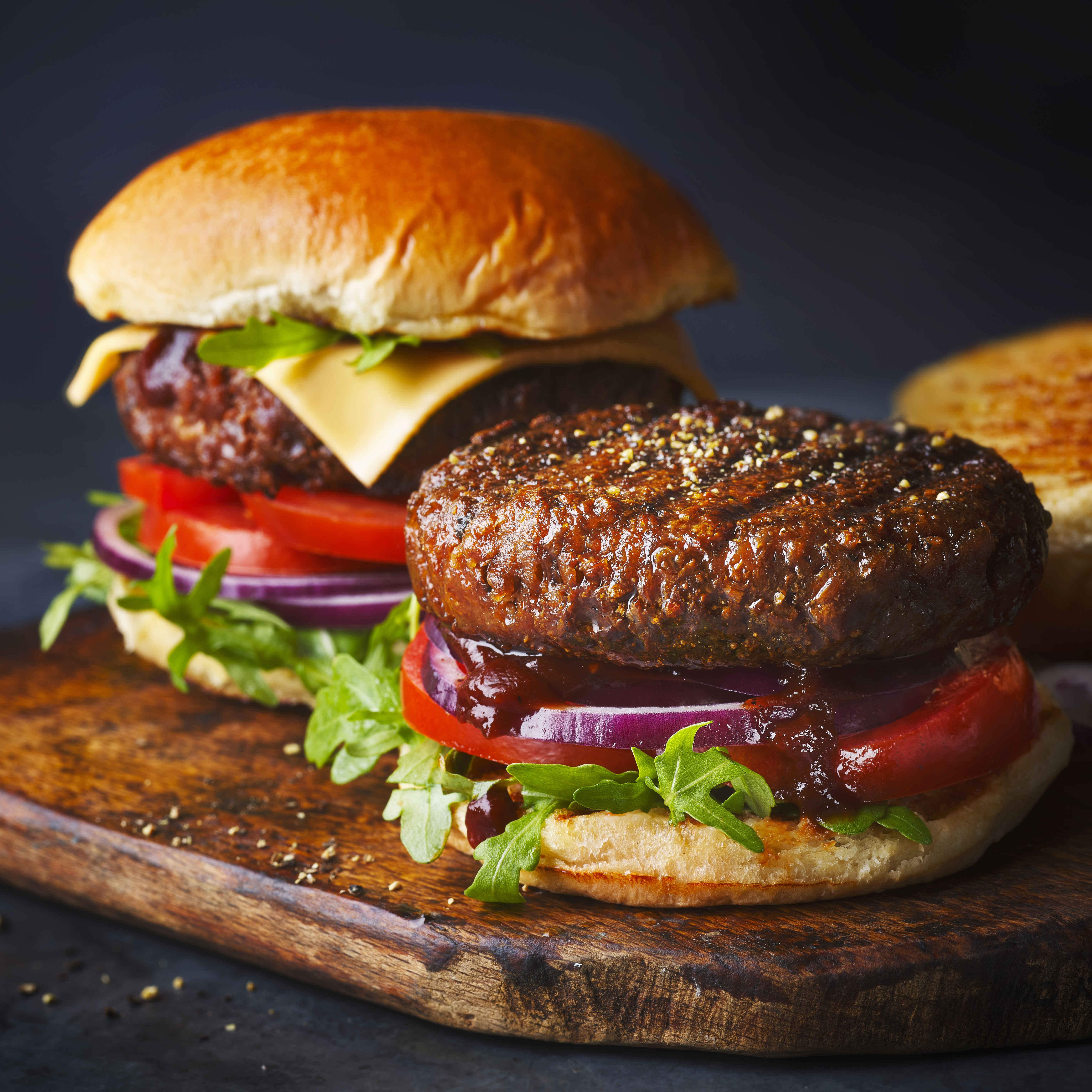 Two vegan burgers on black background