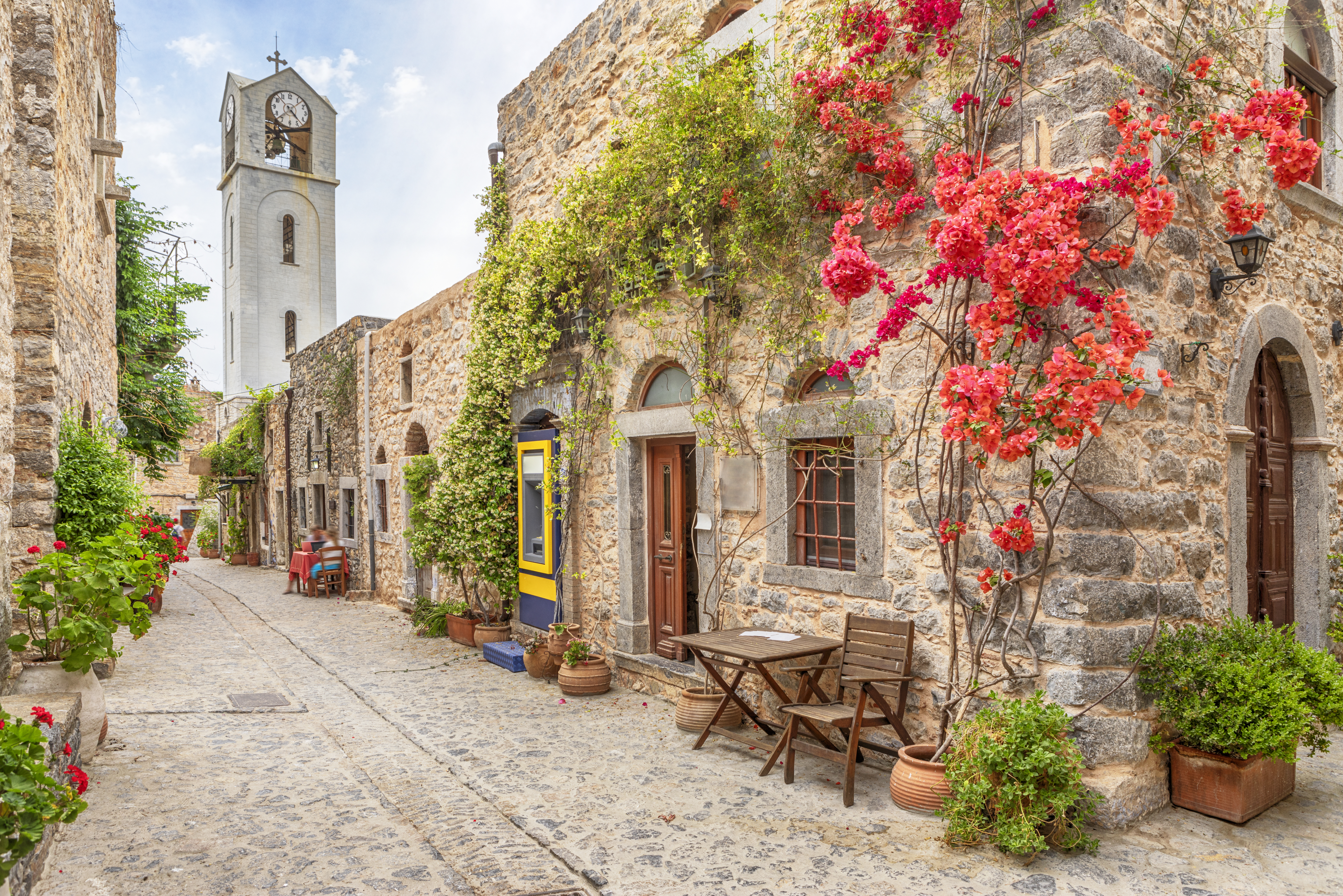 Antike Gasse mit Steinhäusern und Glockenturm in Griechenland