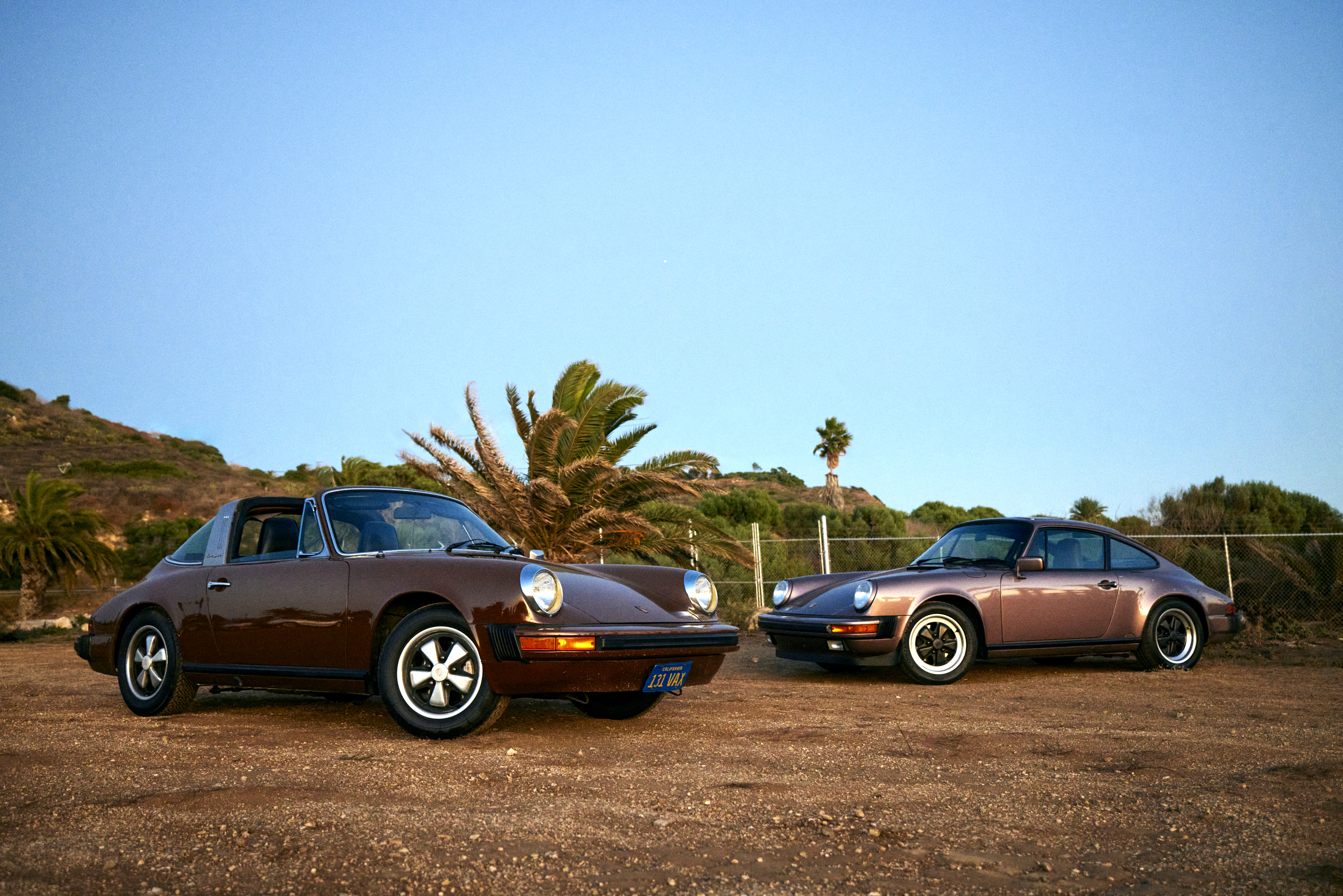 Two Porsche 911 sportscars parked side by side at dusk