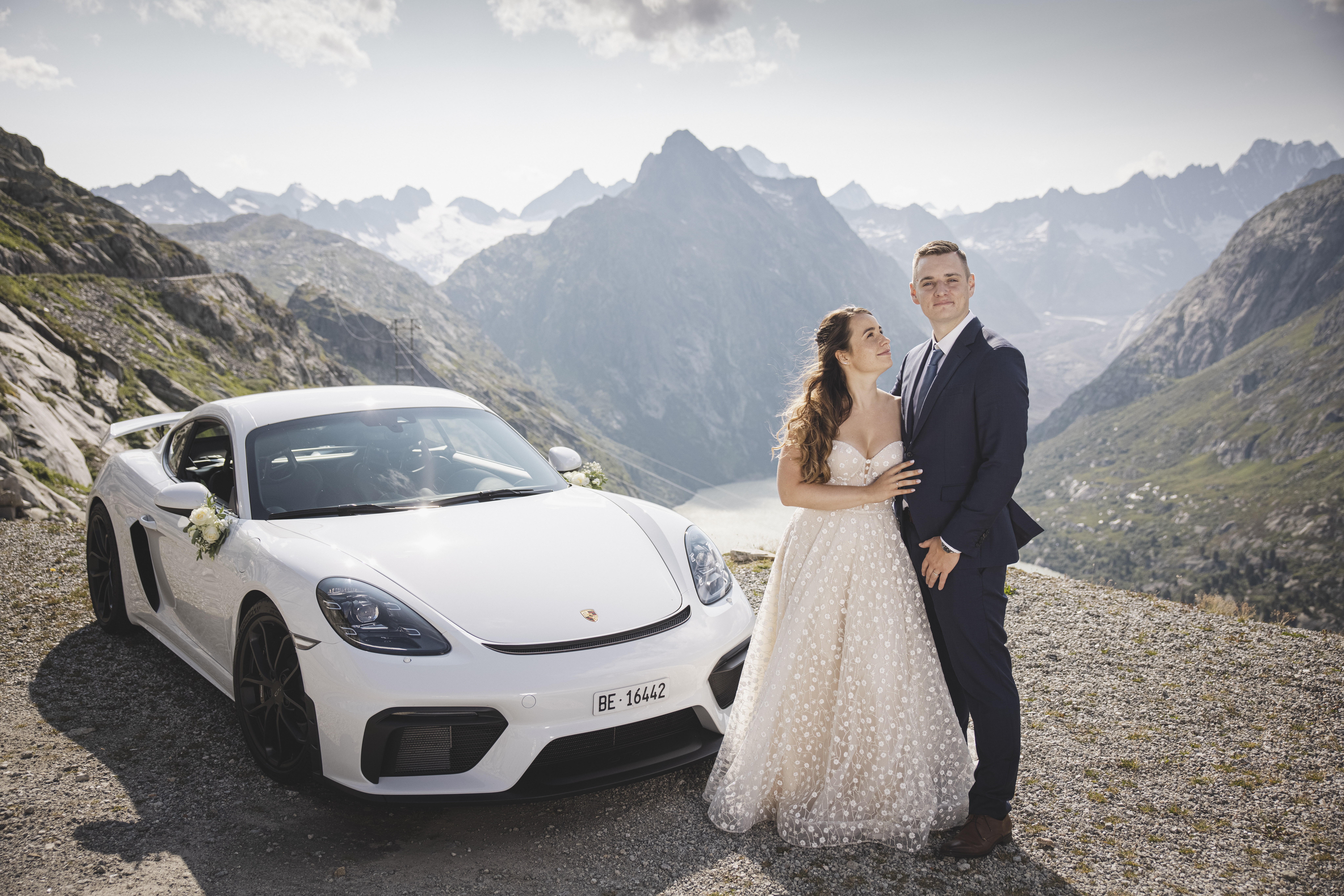 Bride and groom next to white Porsche 718 Cayman GT4