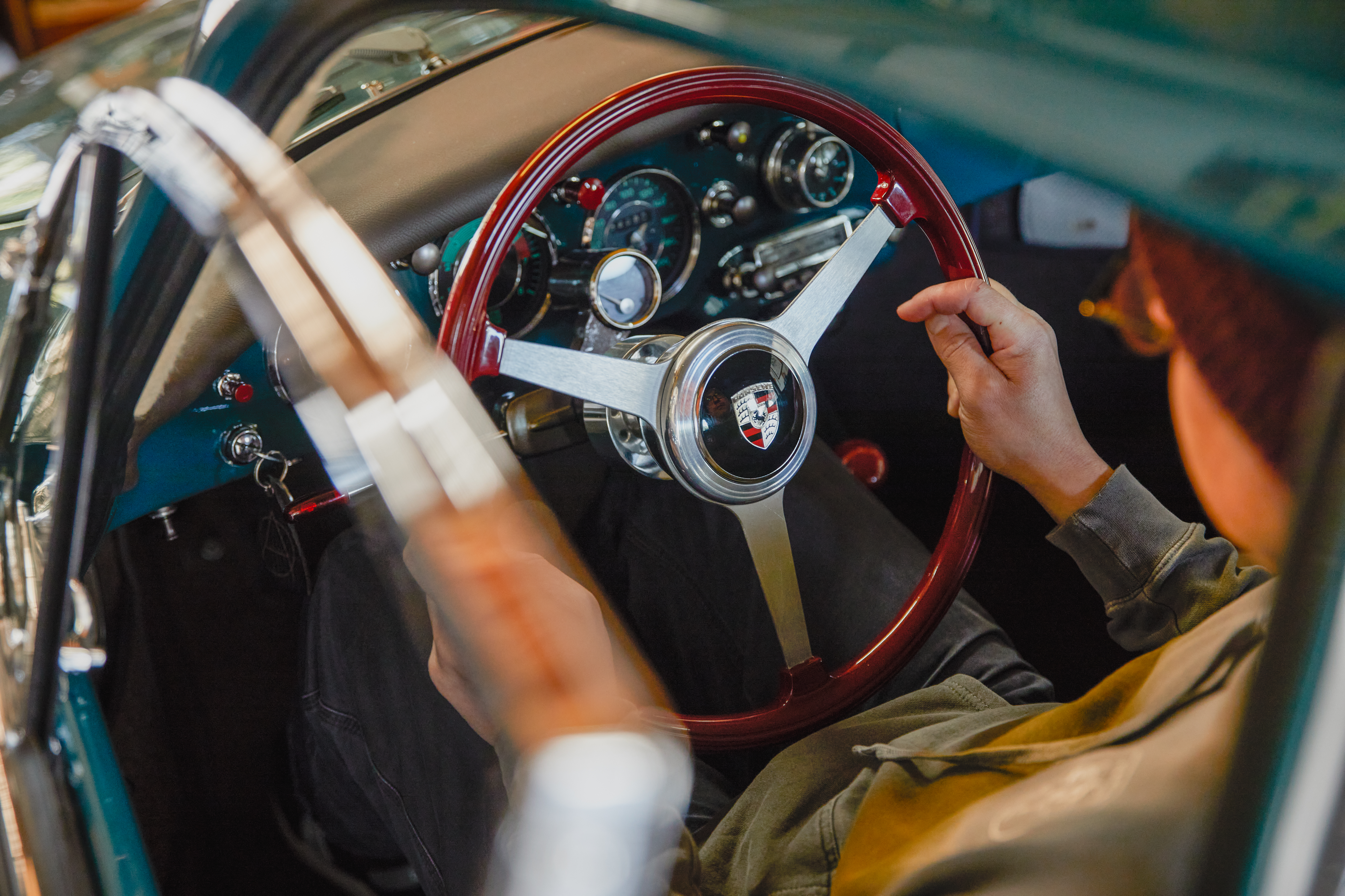 View of car interior with man’s hands on steering wheel