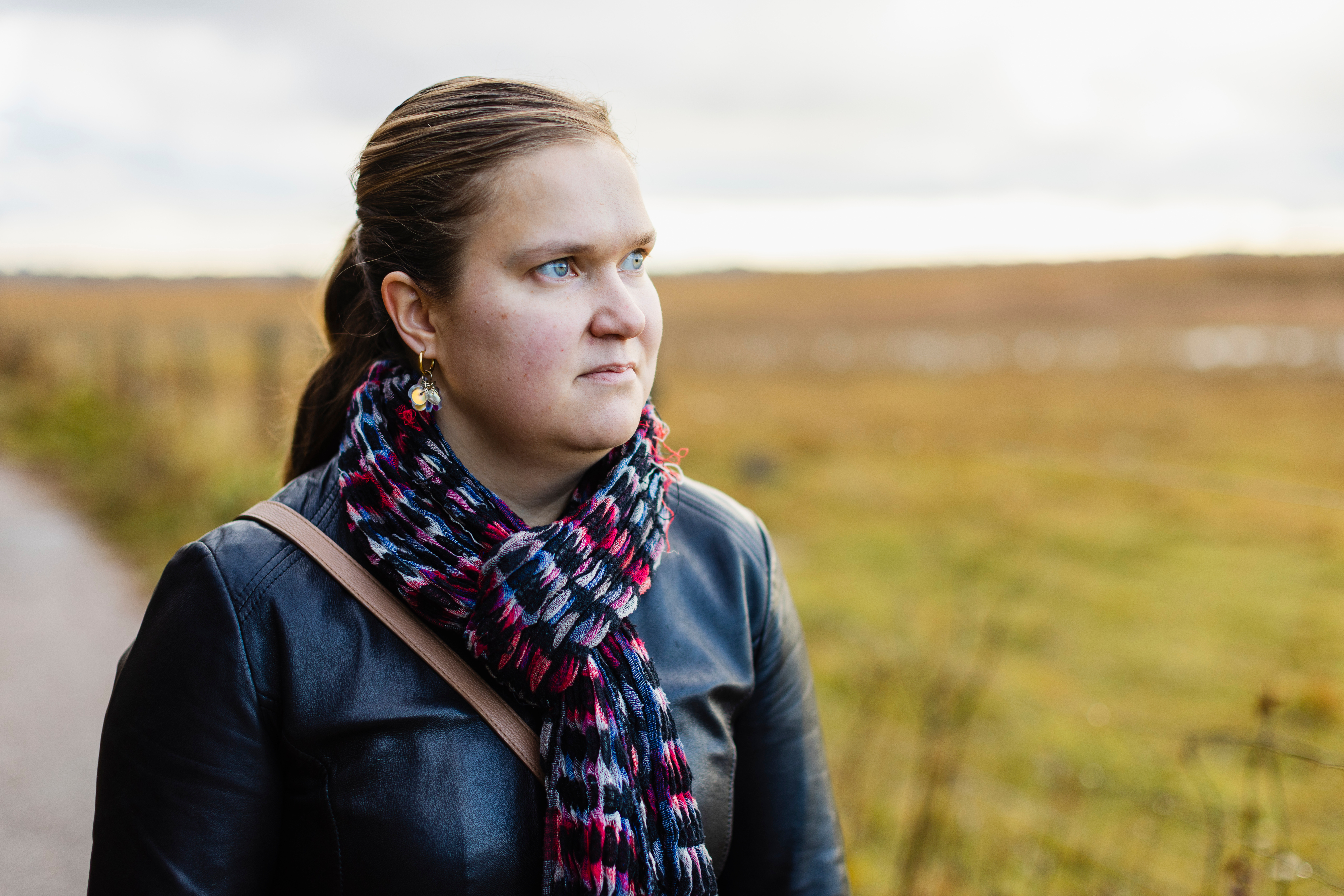 Susanna Halme lähikuvassa, katse oikealle. Taustalla syksyn keltainen avara maisema.