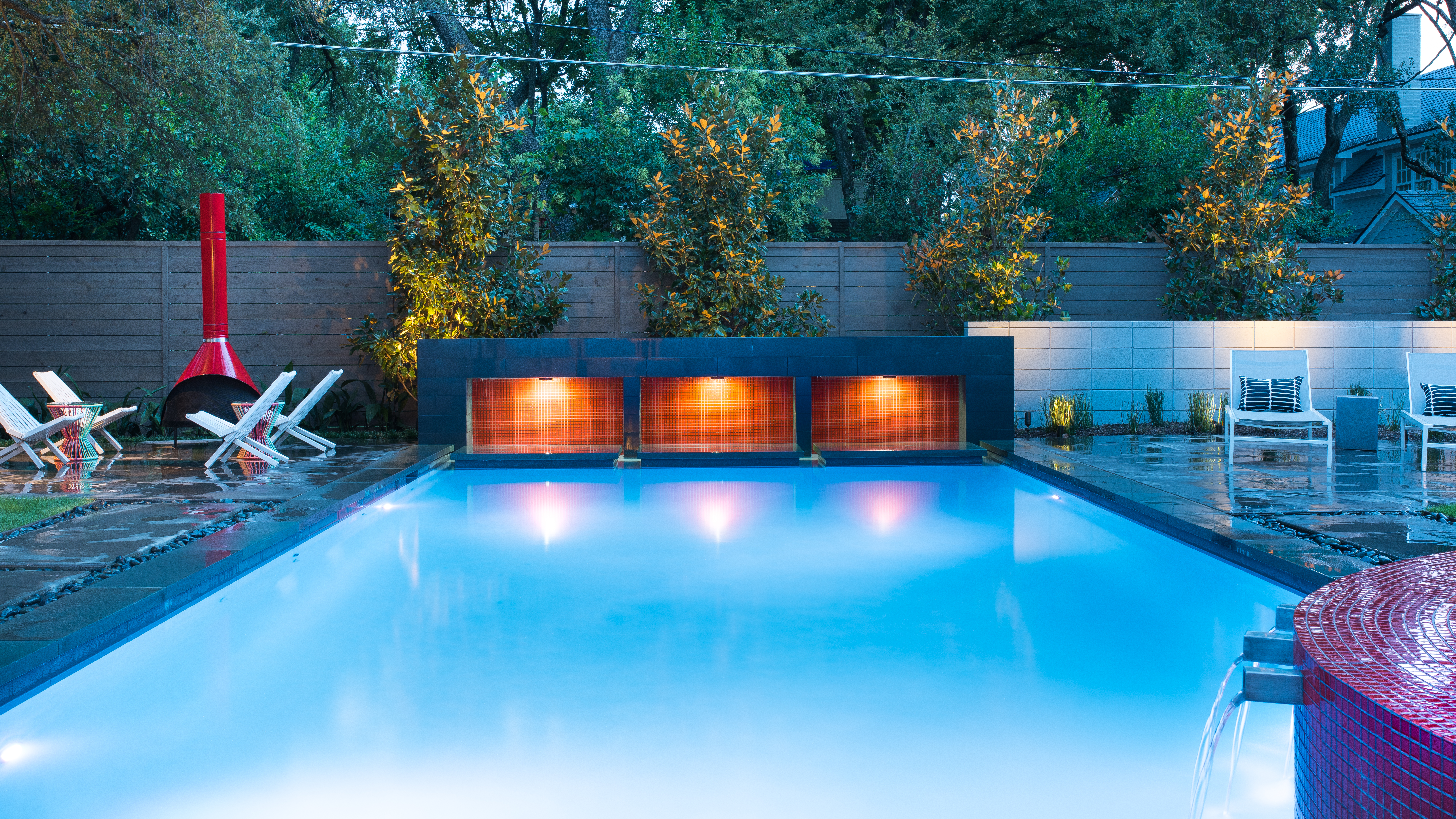 Illuminated swimming pool with modern privacy wall