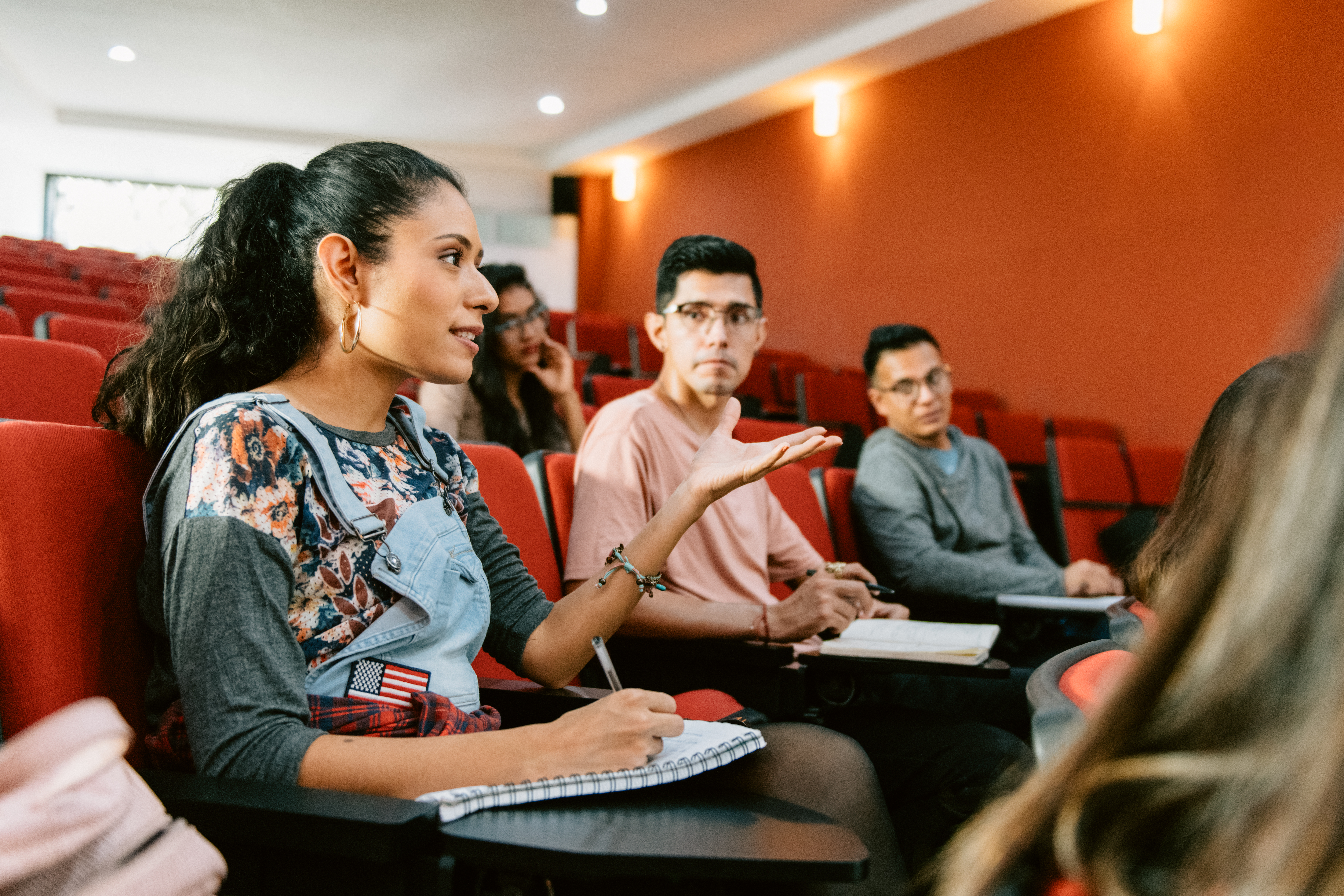 [Imagen destacada]: Un estudiante participa en clase y toma apuntes para obtener créditos universitarios.
