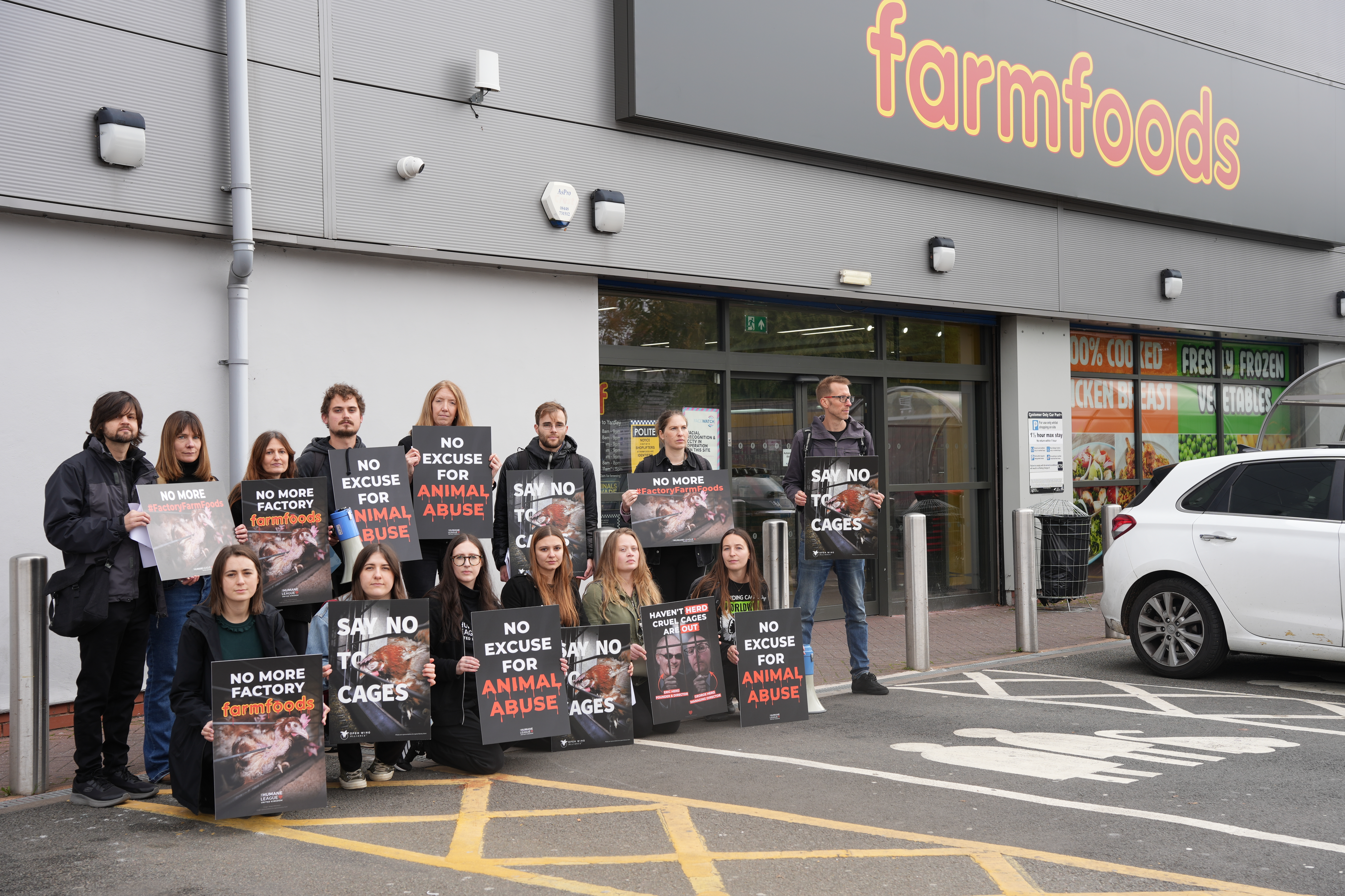 Group of protesters stand in front of Farmfoods offices