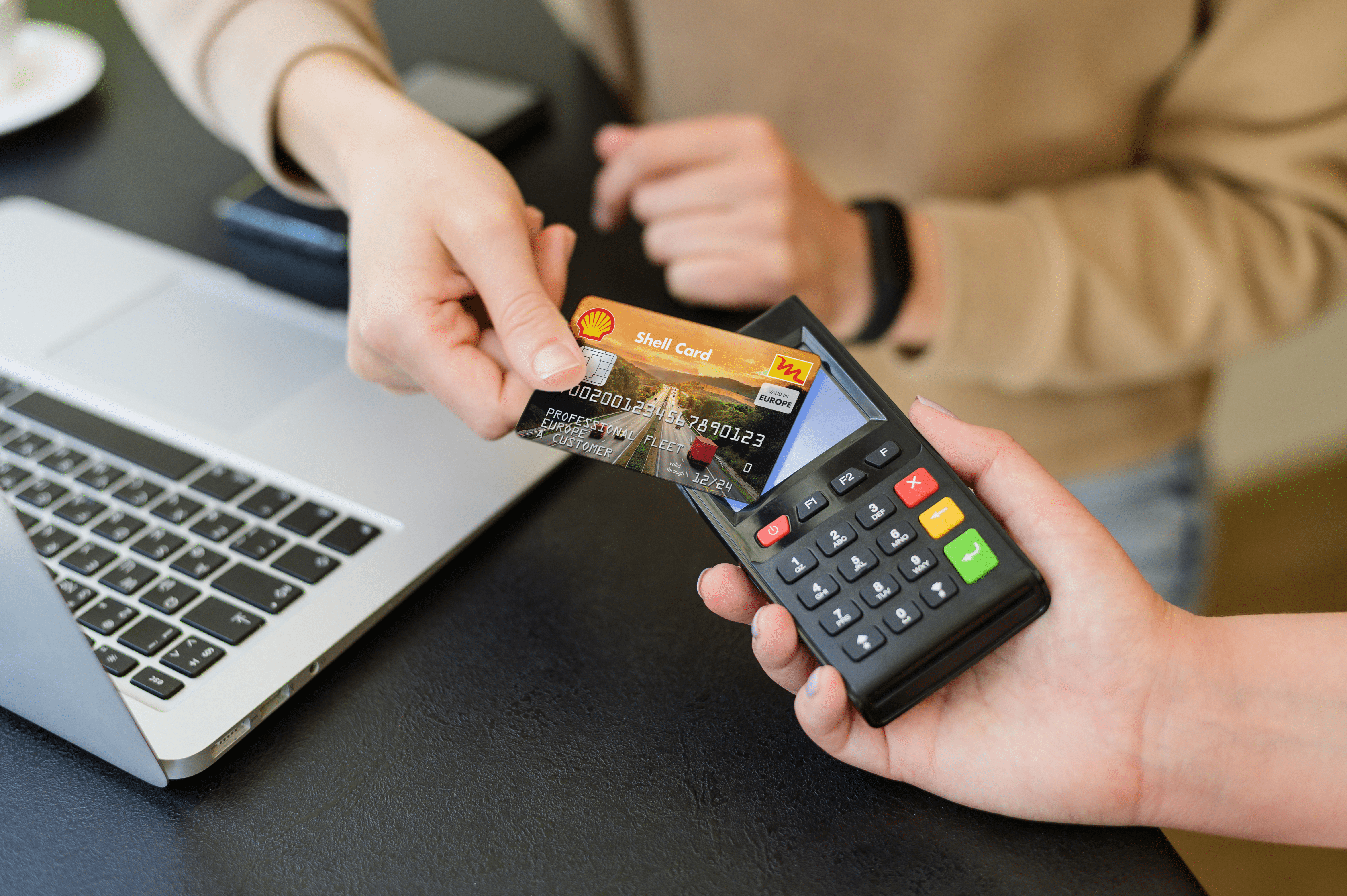 Un collaborateur utilise la carte Shell avec un terminal de paiement pour payer son plein d’essence. 