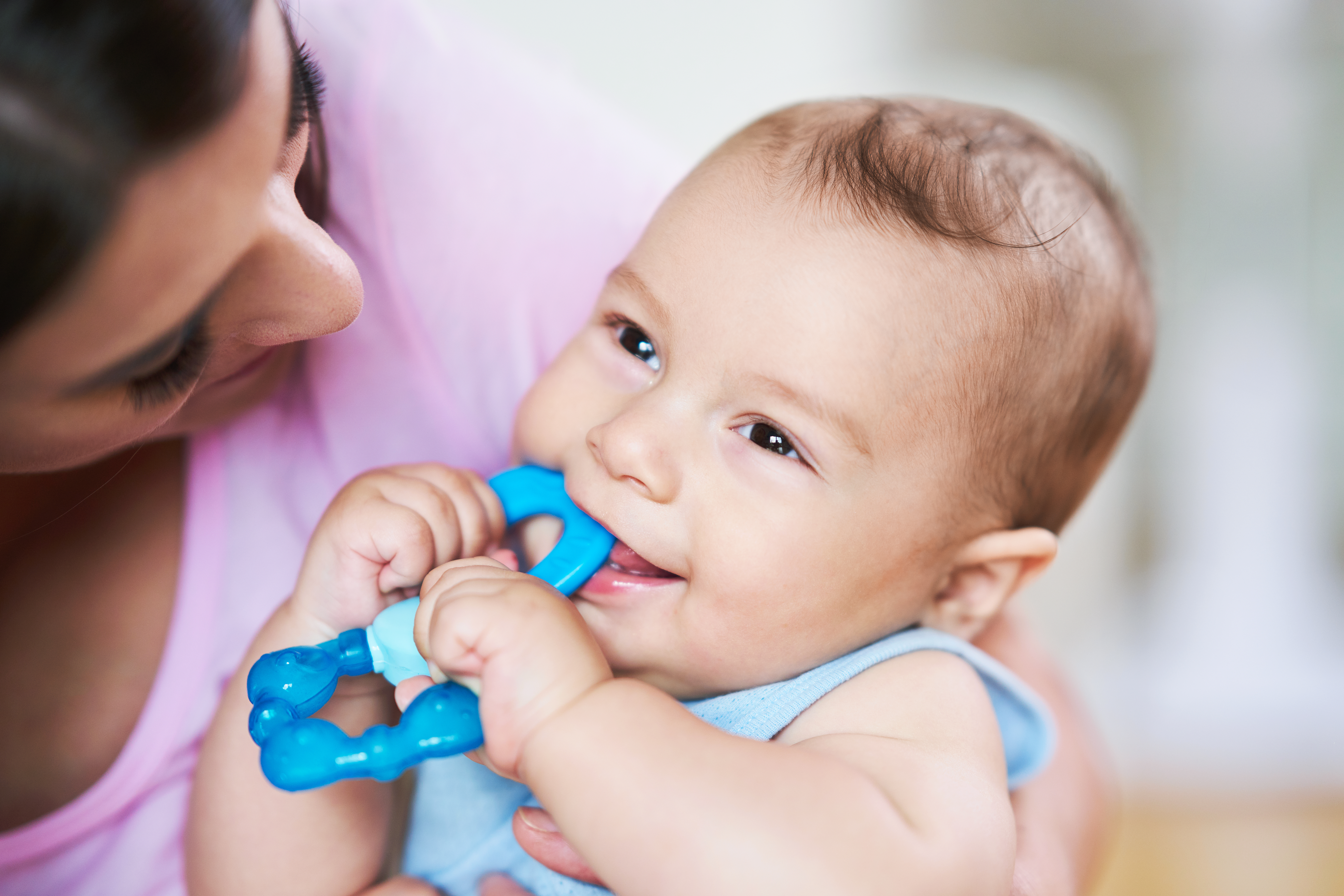 Mom looking at baby bite on blue pacifier