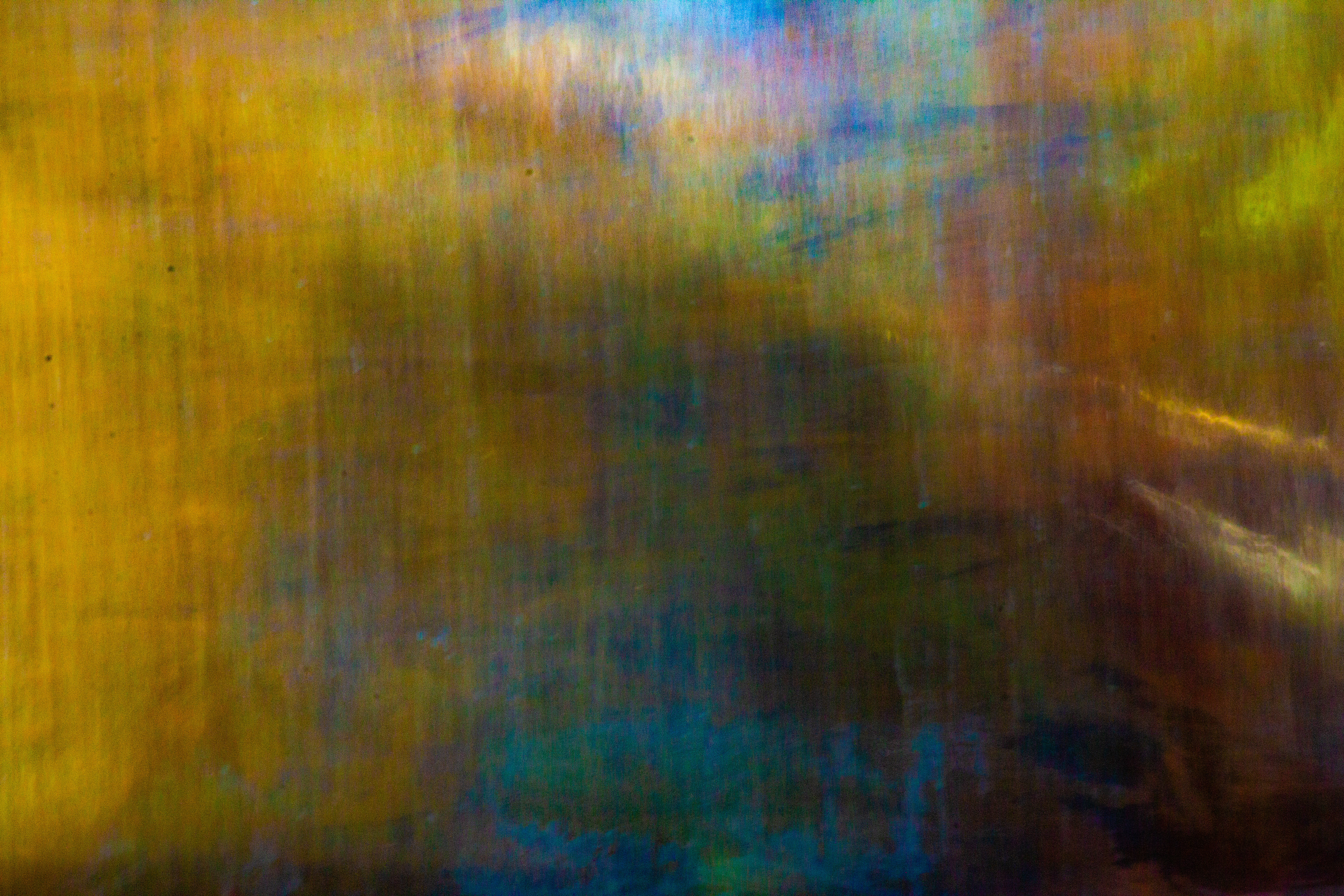 A close up photograph of some water in front of a metal plate.