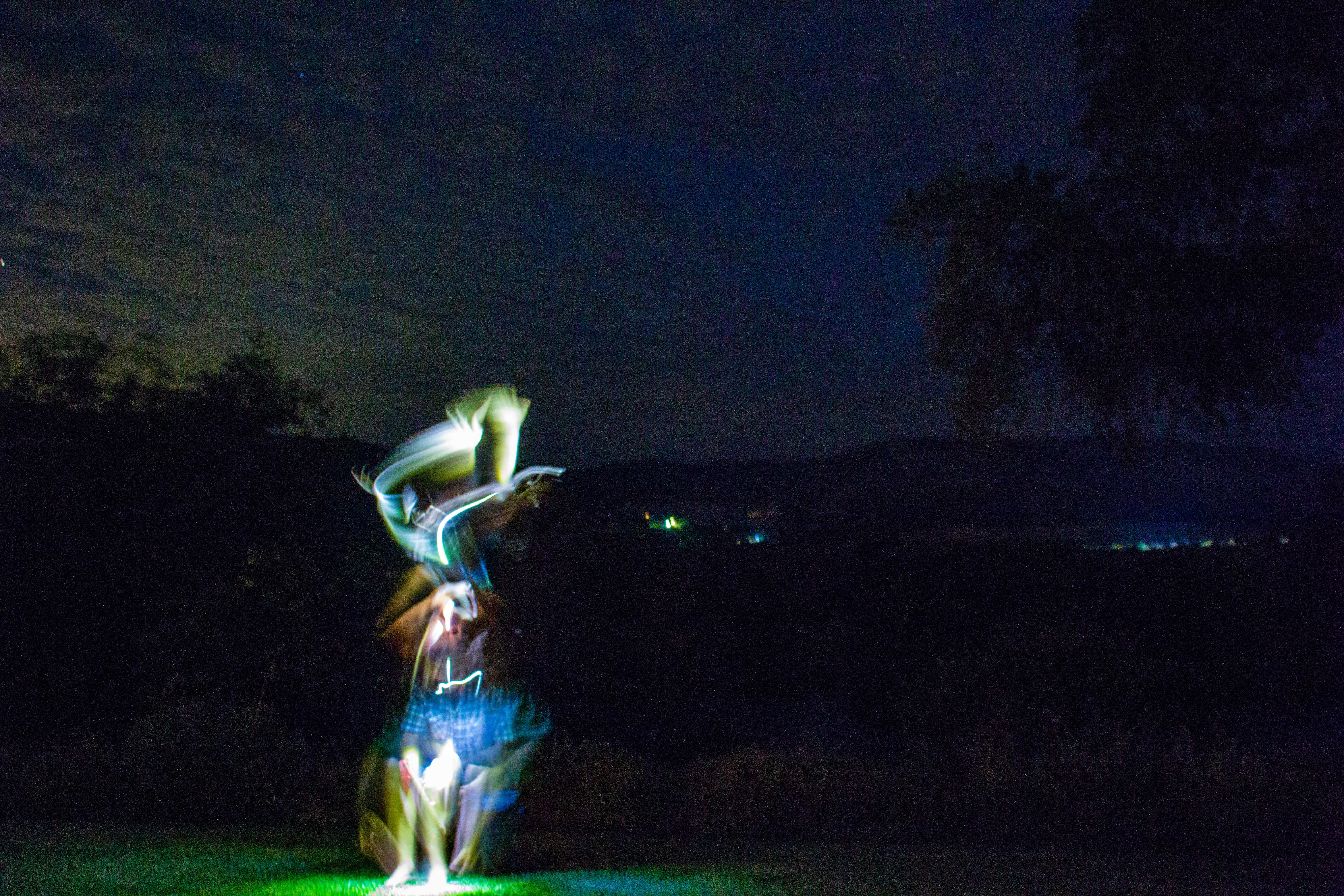 A photograph of a dancing light in the night.